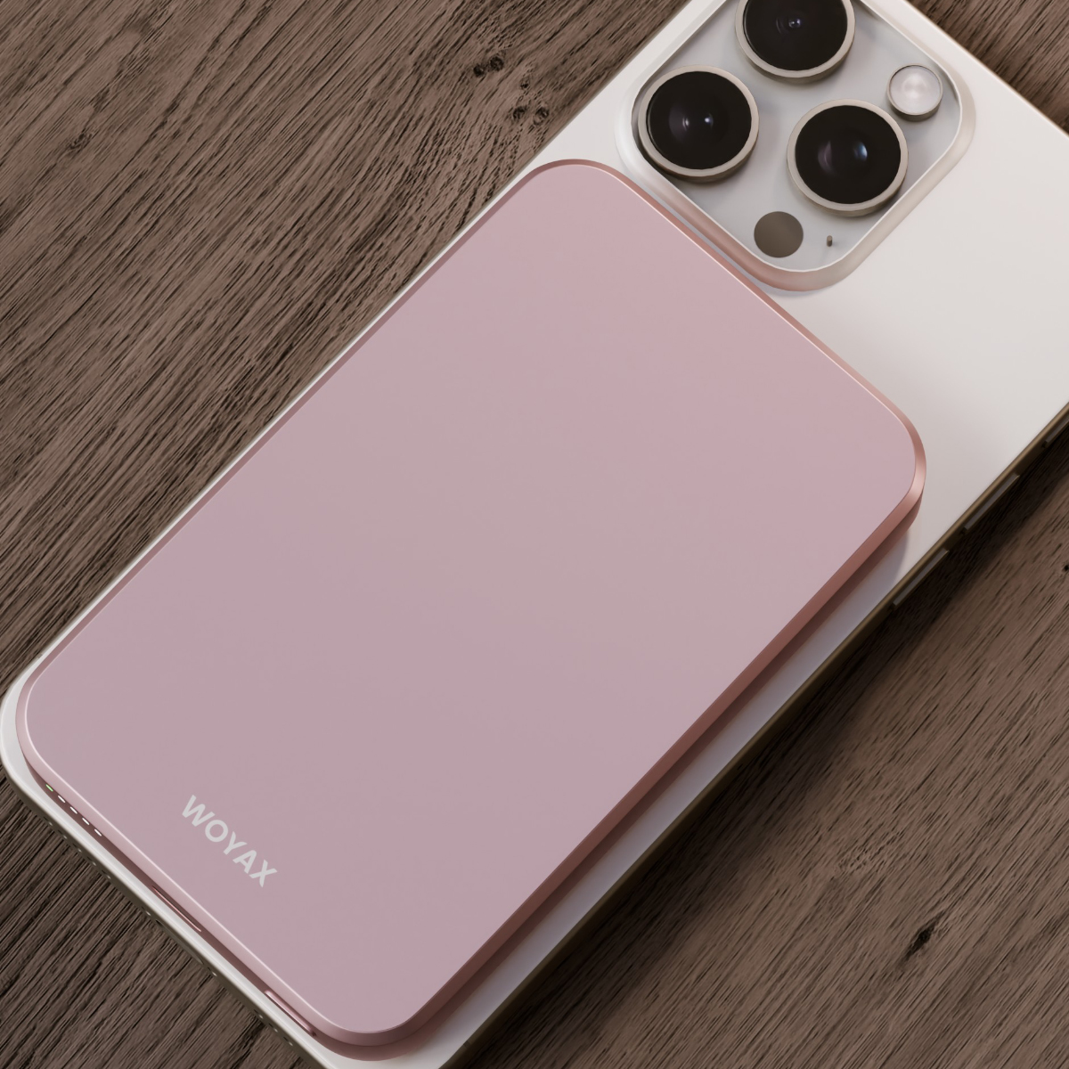 WOYAX logolu pembe bir akıllı telefon, beyaz bir akıllı telefonun yanında ahşap bir masada duruyor.