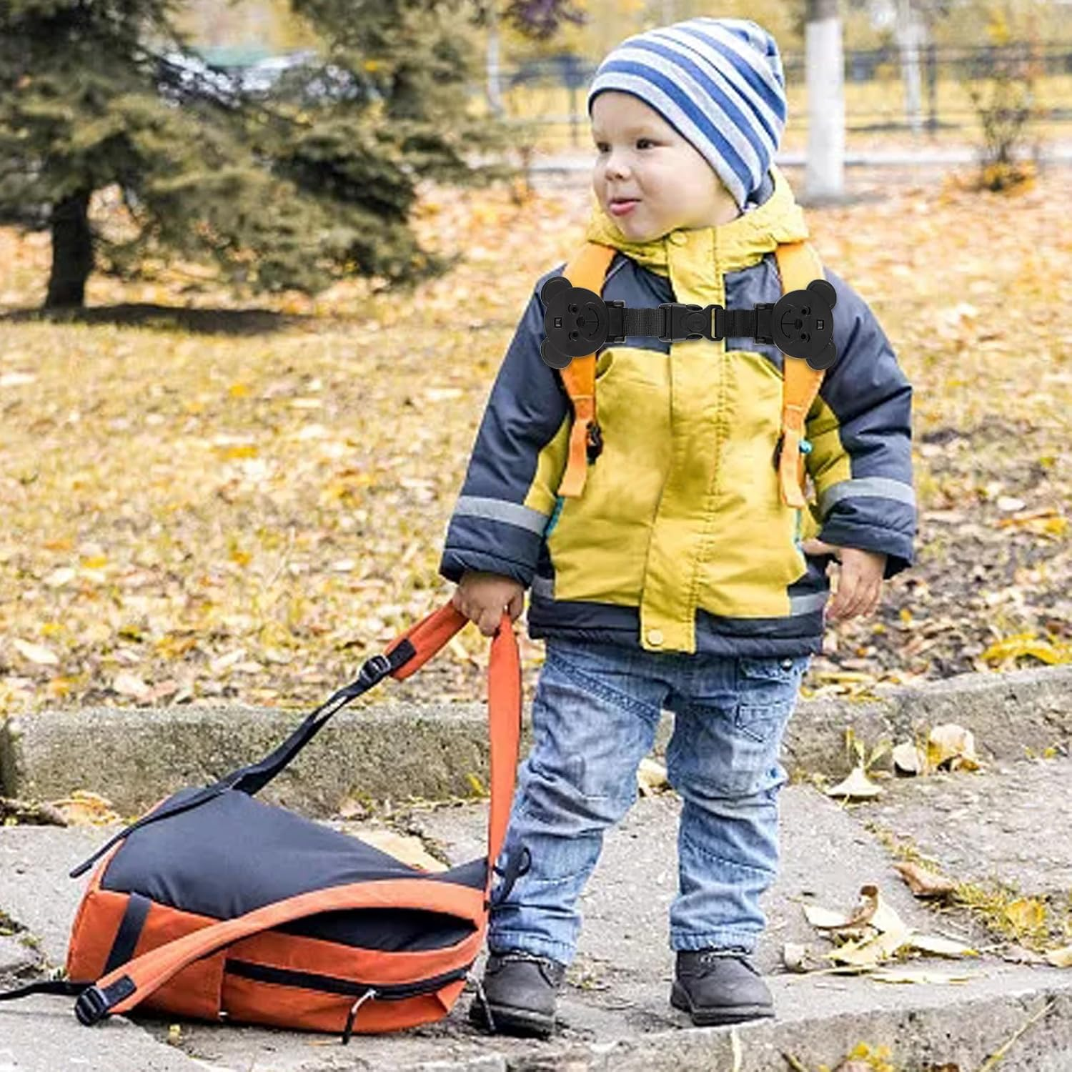 Ein kleiner Junge mit Rucksack und Tasche im Herbst.
