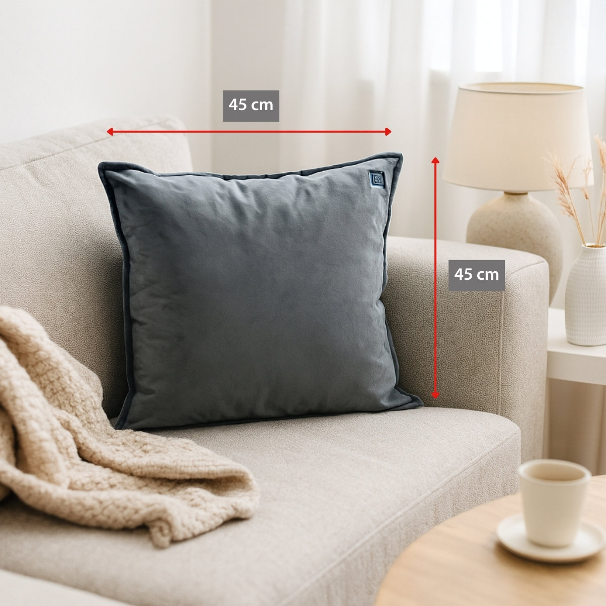 A grey cushion with 45 cm dimensions on a sofa.