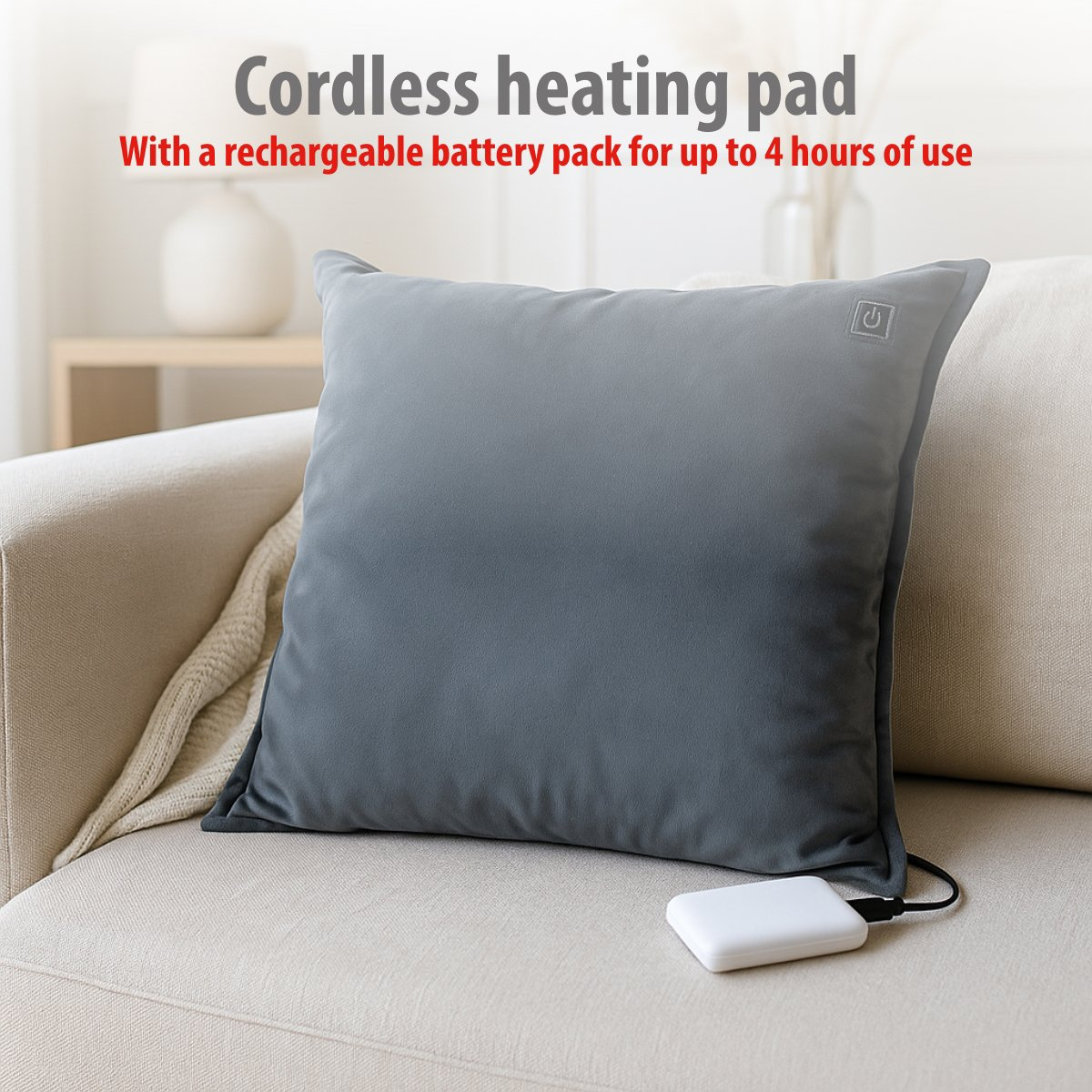 Gray heating pad with a white battery pack on a sofa.