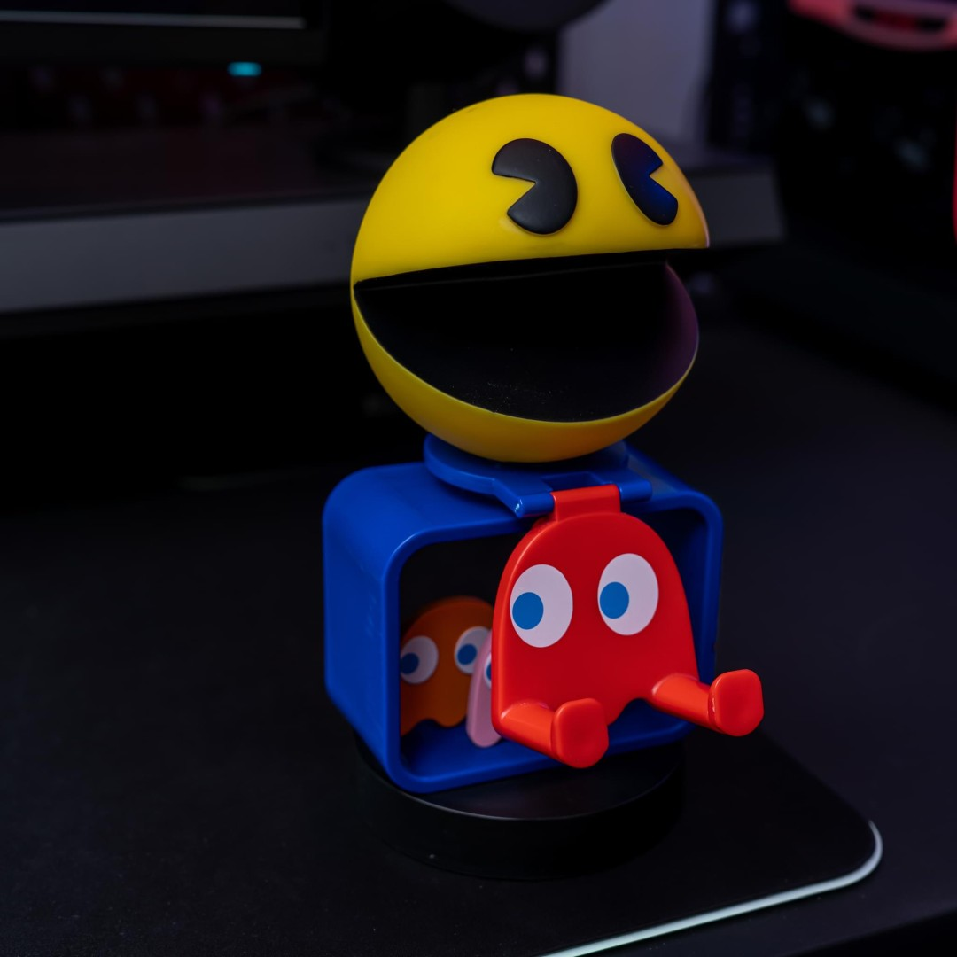 Pac-Man giallo su supporto blu con fantasmi rossi e arancioni.