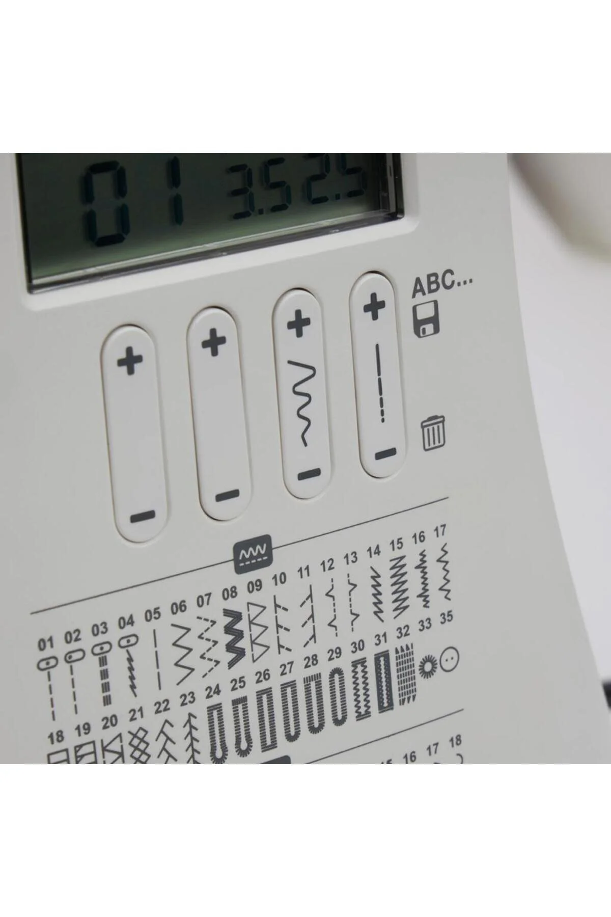 Bedienfeld einer Nähmaschine mit digitaler Anzeige, Knöpfen und Stichmustern.