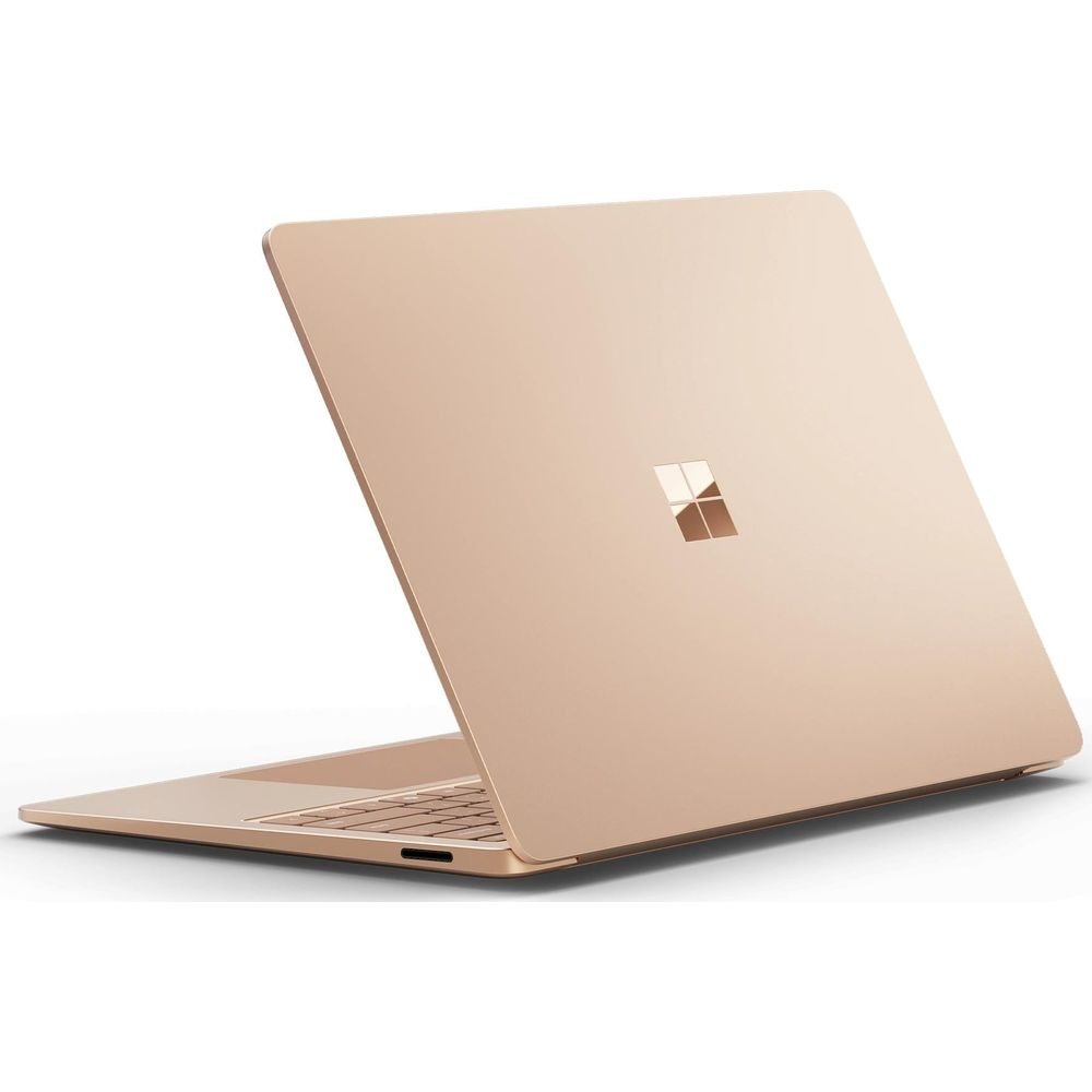 Ein geöffneter, goldfarbener Laptop mit dem Microsoft-Logo auf dem Deckel.