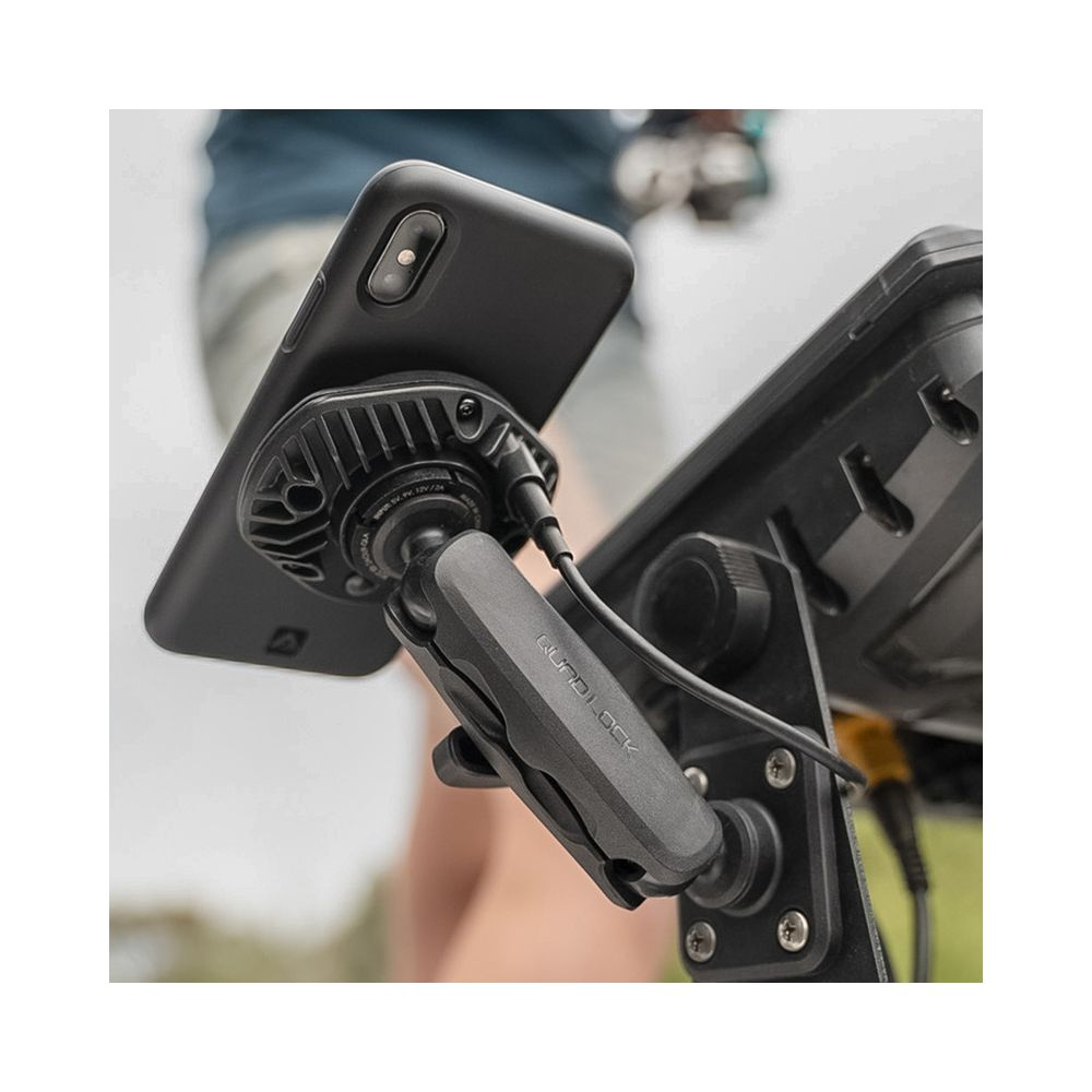 Un téléphone noir fixé à un support sur un appareil. Un câble se connecte au téléphone.