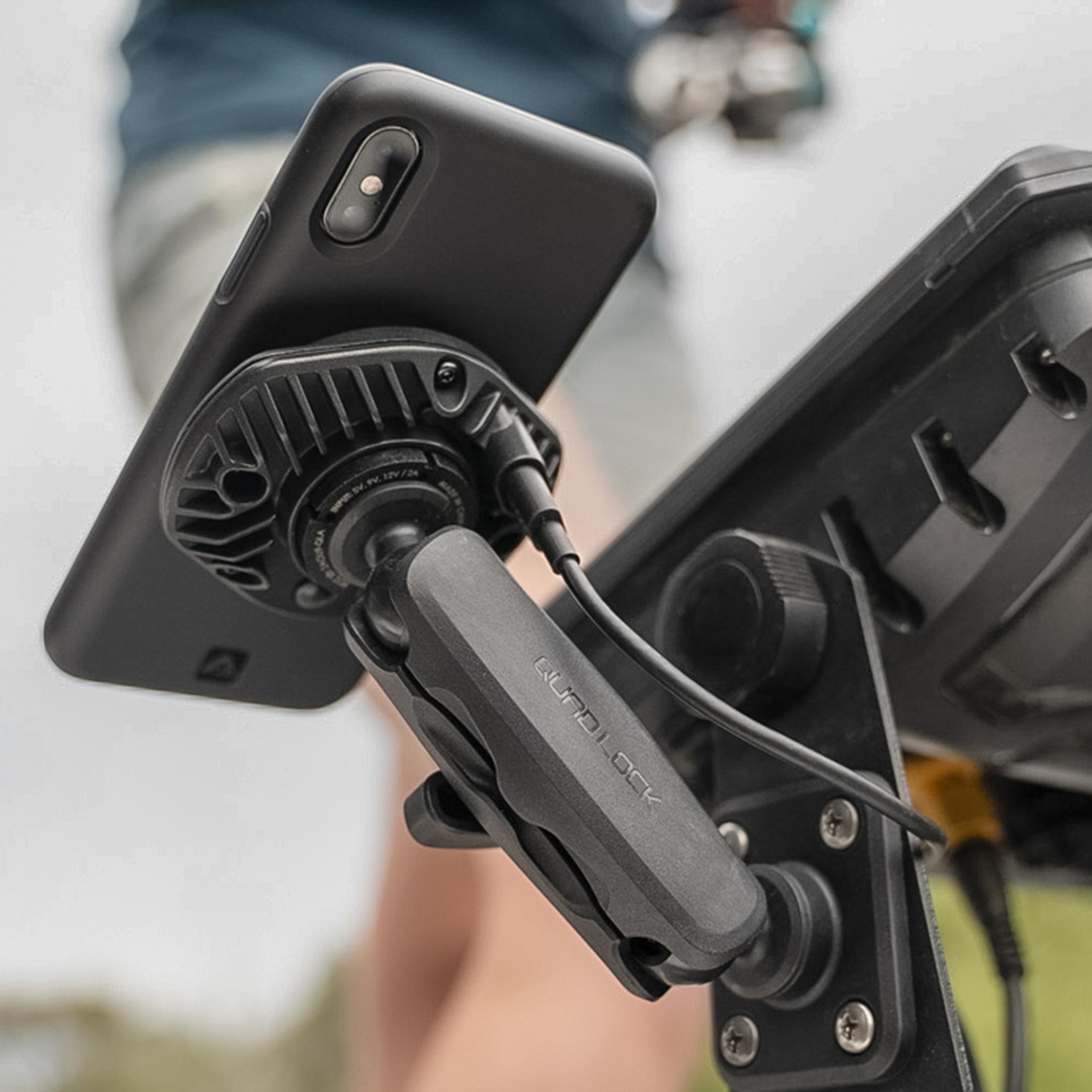 Un téléphone noir est monté sur un support fixé à un autre appareil.
