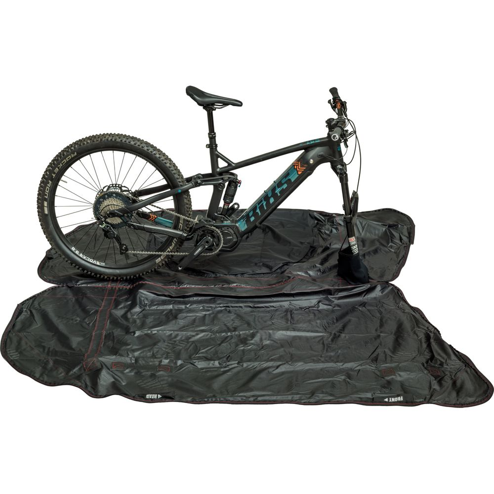 Un VAE noir repose sur un sac de vélo noir avec coutures rouges.