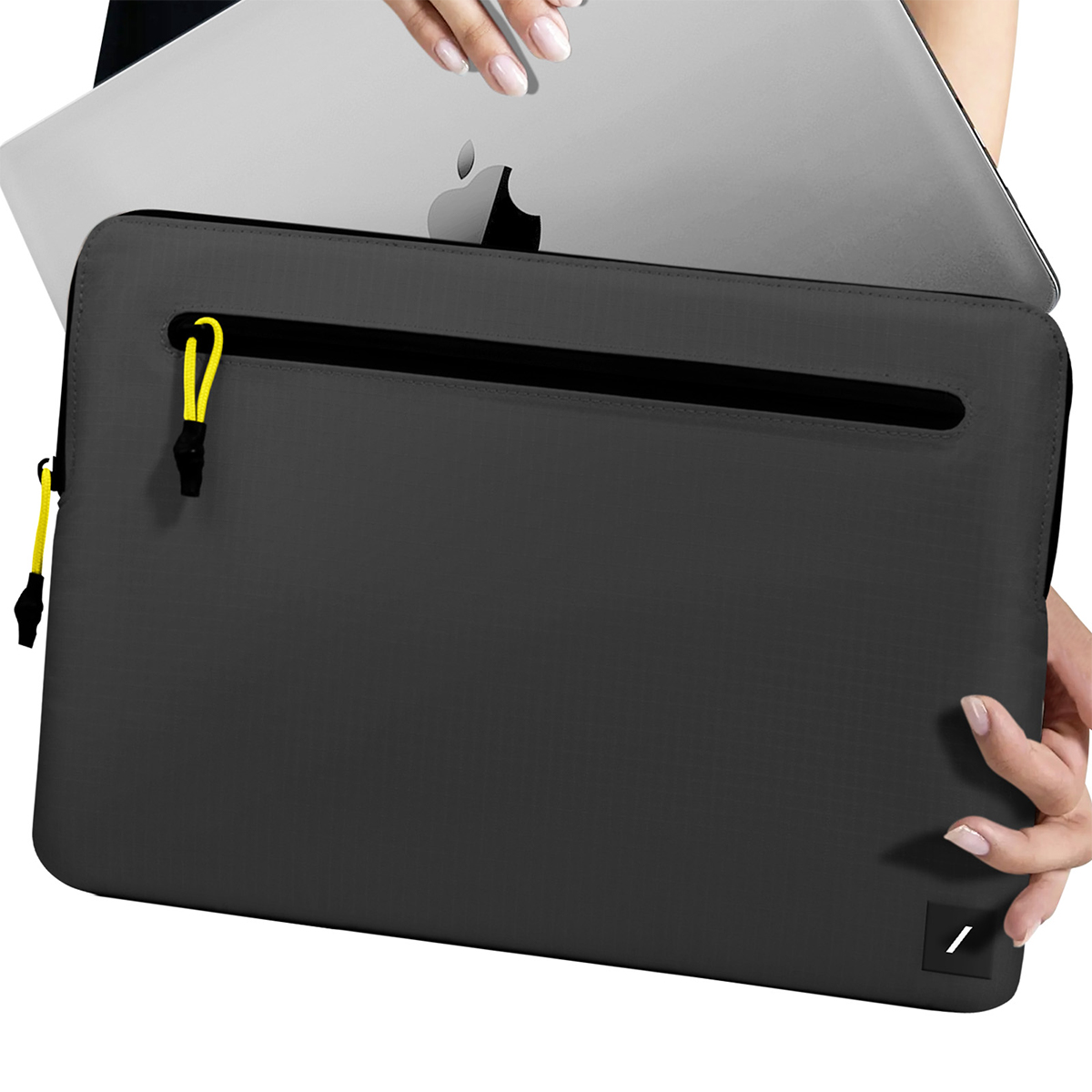 Grijze laptoptas met gele ritslip, Apple laptop wordt ingeschoven.