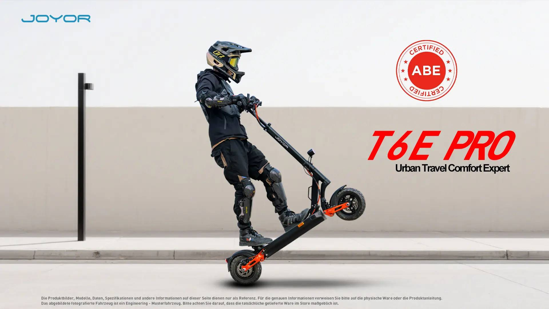 Ein Mann mit Helm und Schutzkleidung fährt einen schwarzen E-Scooter mit orangen Akzenten.
