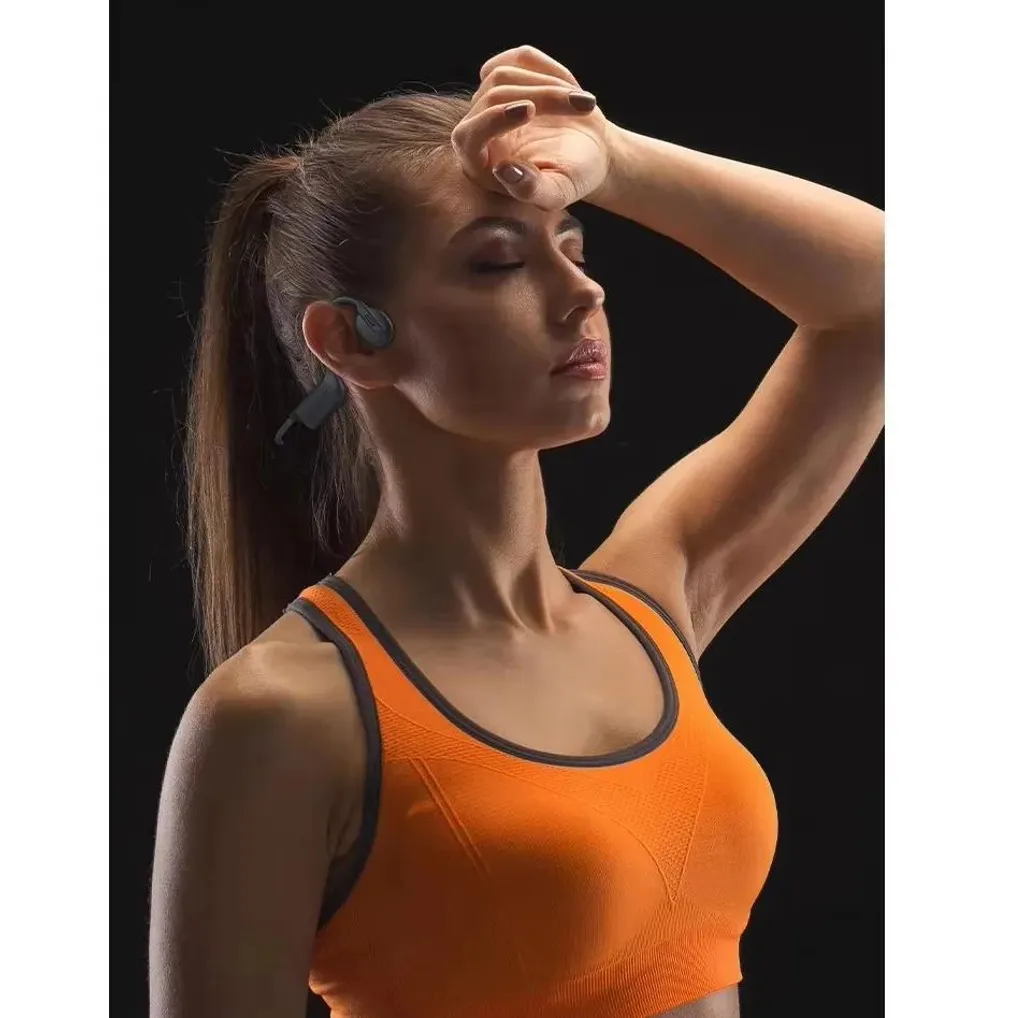 Eine Frau mit Stirnband und Sport-BH wischt sich die Stirn.