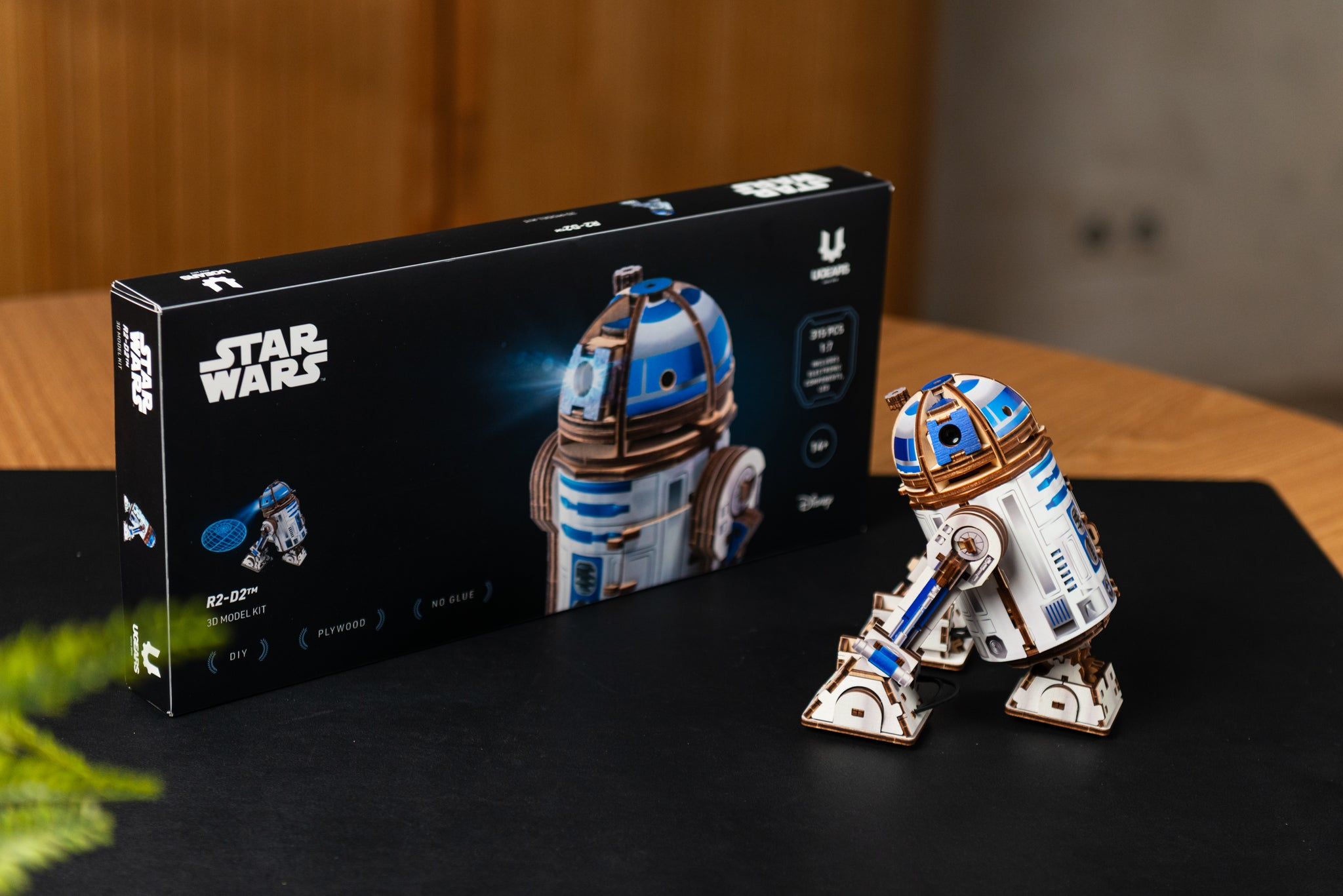 Star Wars R2-D2 3D-Modellbausatzschachtel und zusammengebautes Modell auf schwarzer Oberfläche.