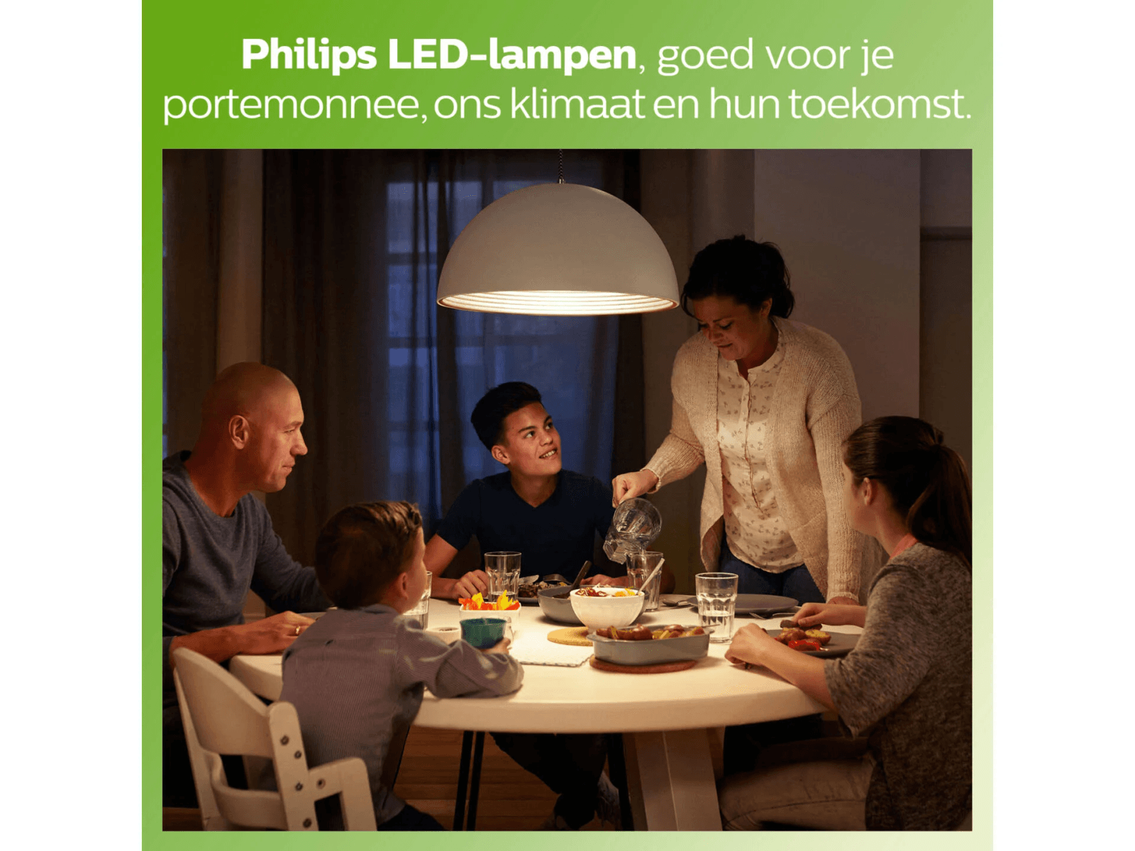 Une famille dîne ensemble sous une lampe LED Philips.