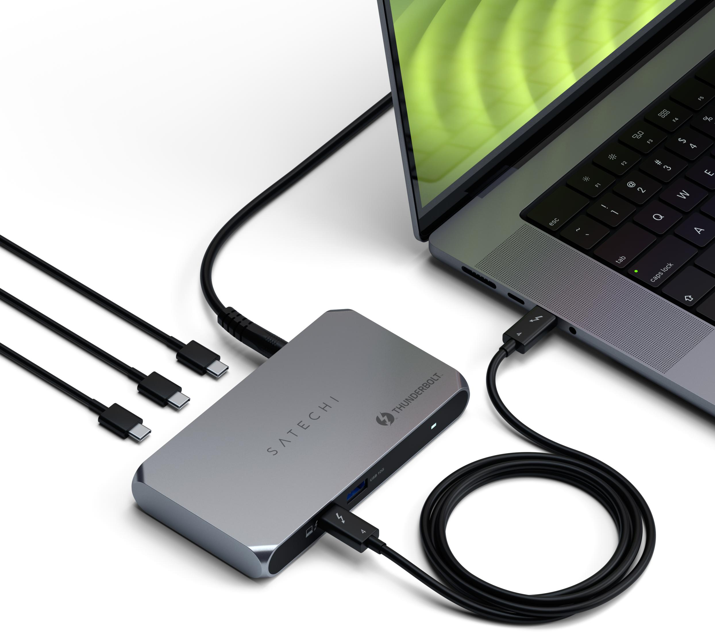 Un hub Satechi grigio è collegato a un laptop. Diversi cavi USB-C sono collegati.