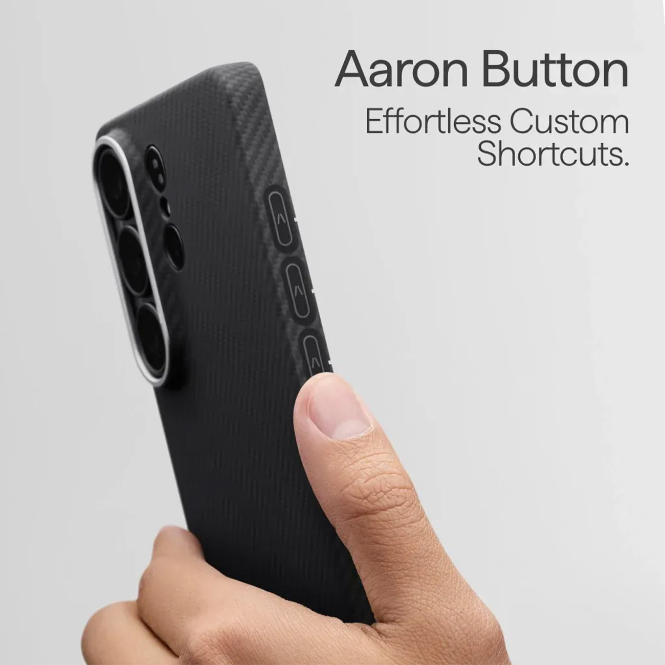 Una mano sostiene una funda de teléfono negra de fibra de carbono con un bulto de cámara. Texto: 'Aaron Button'.