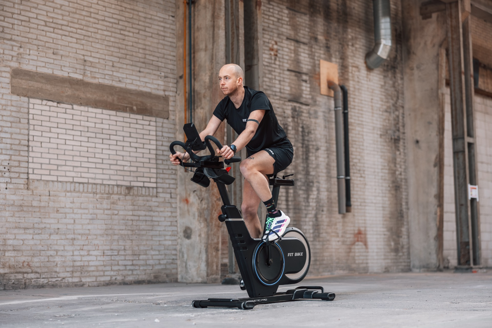 Un homme sur un vélo d'intérieur dans un espace industriel.