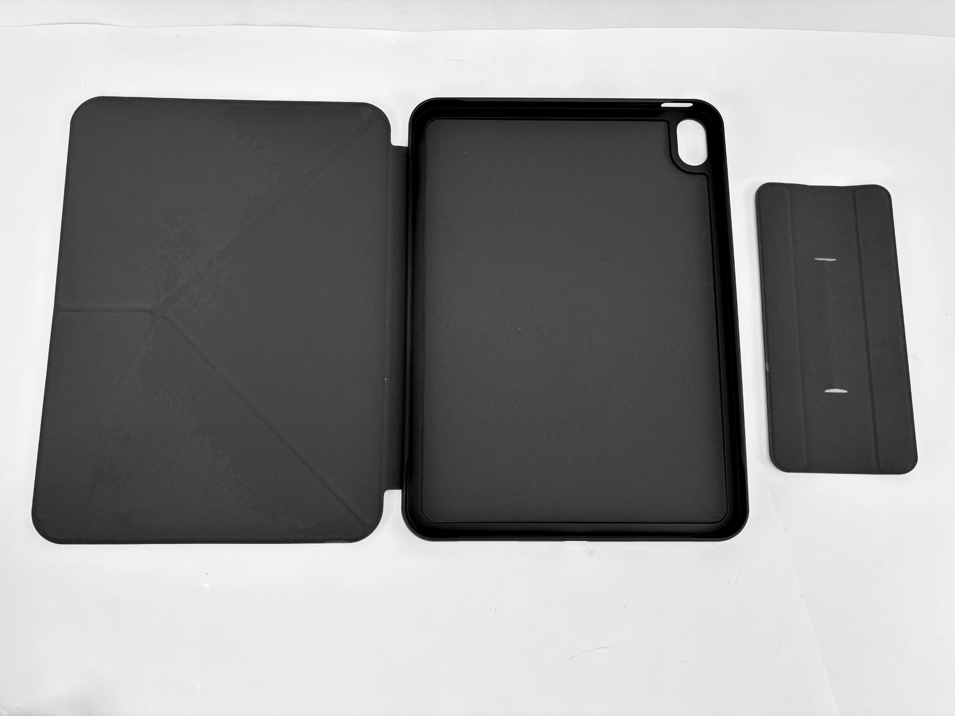 Tre custodie nere per tablet sono disposte una accanto all'altra su sfondo bianco.
