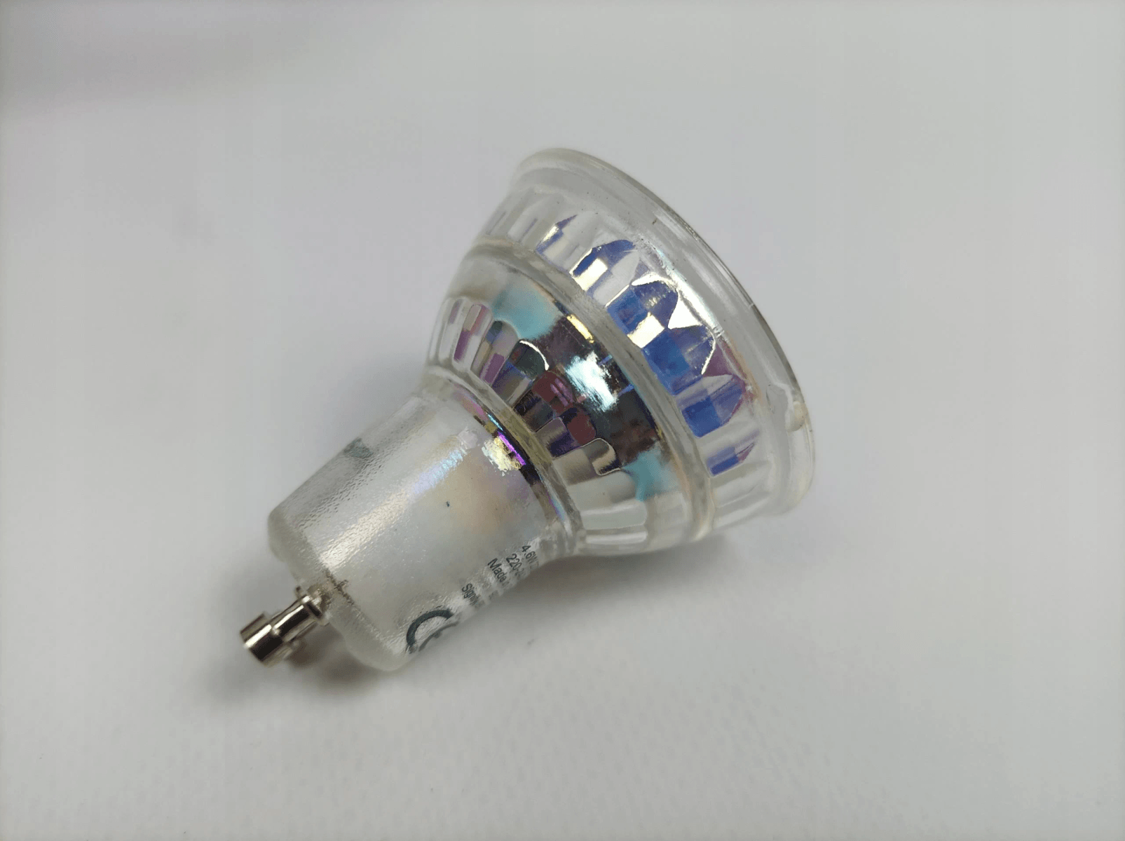 Een heldere LED-lamp met zilveren voet op een witte achtergrond.