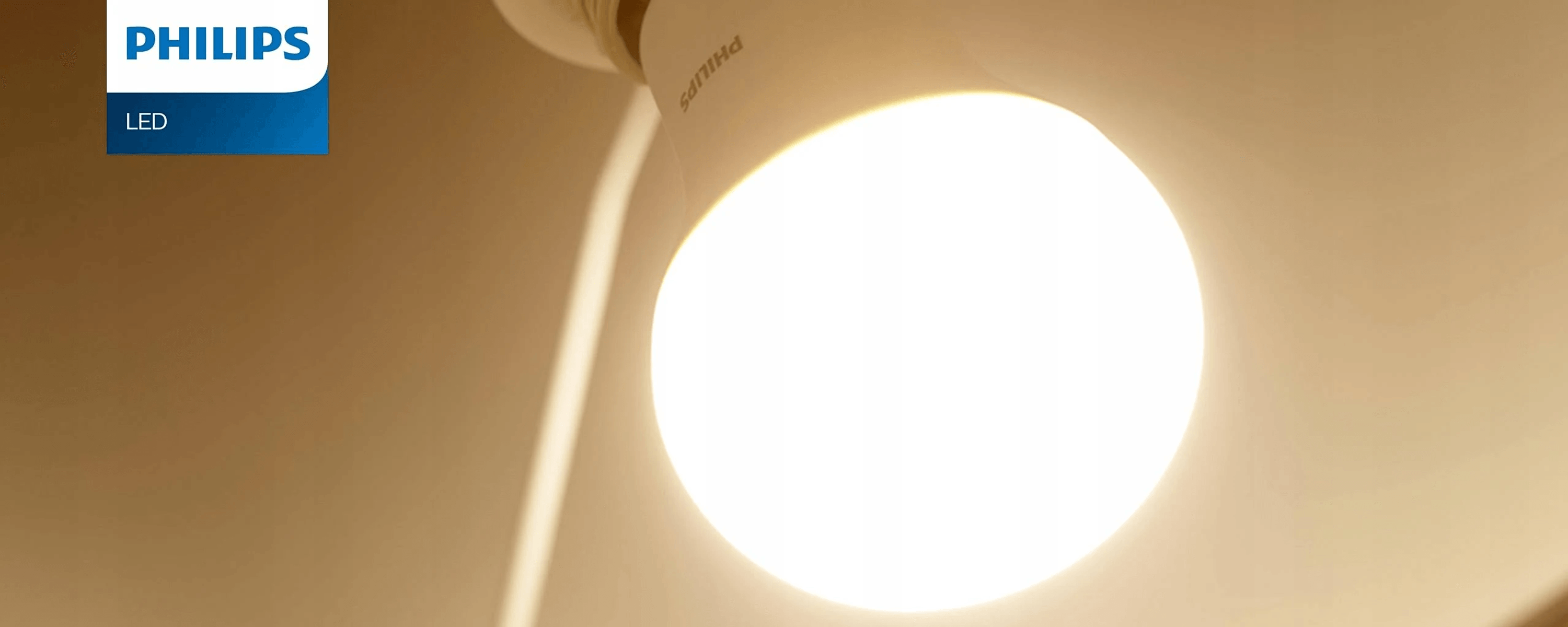 Een heldere Philips LED-lamp met logo op beige achtergrond.