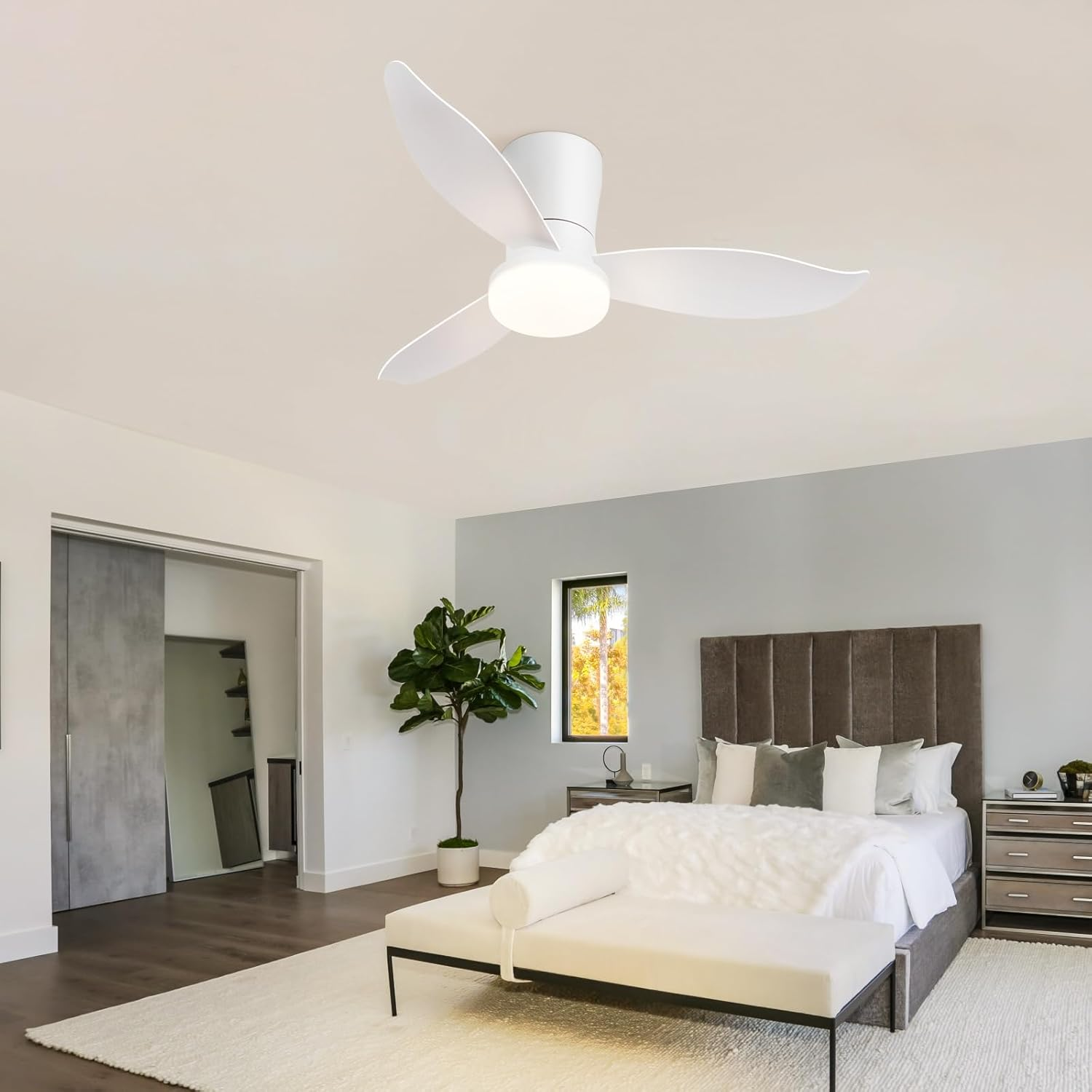 Una camera da letto con ventilatore a soffitto, letto con testiera marrone e tappeto bianco.