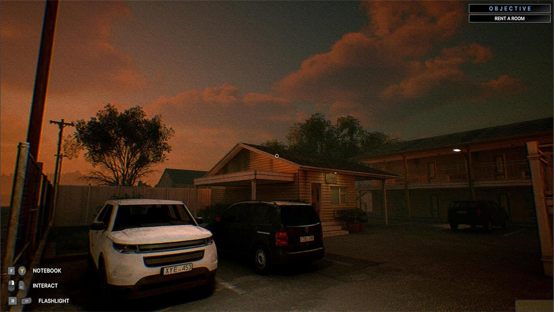 Motel al tramonto. SUV bianco e furgone scuro parcheggiati fuori ufficio e camere.