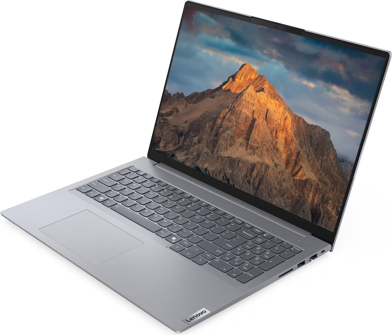 Gümüş renkli bir Lenovo dizüstü bilgisayar açık, ekranında gün batımında bir dağ zirvesi görünüyor.