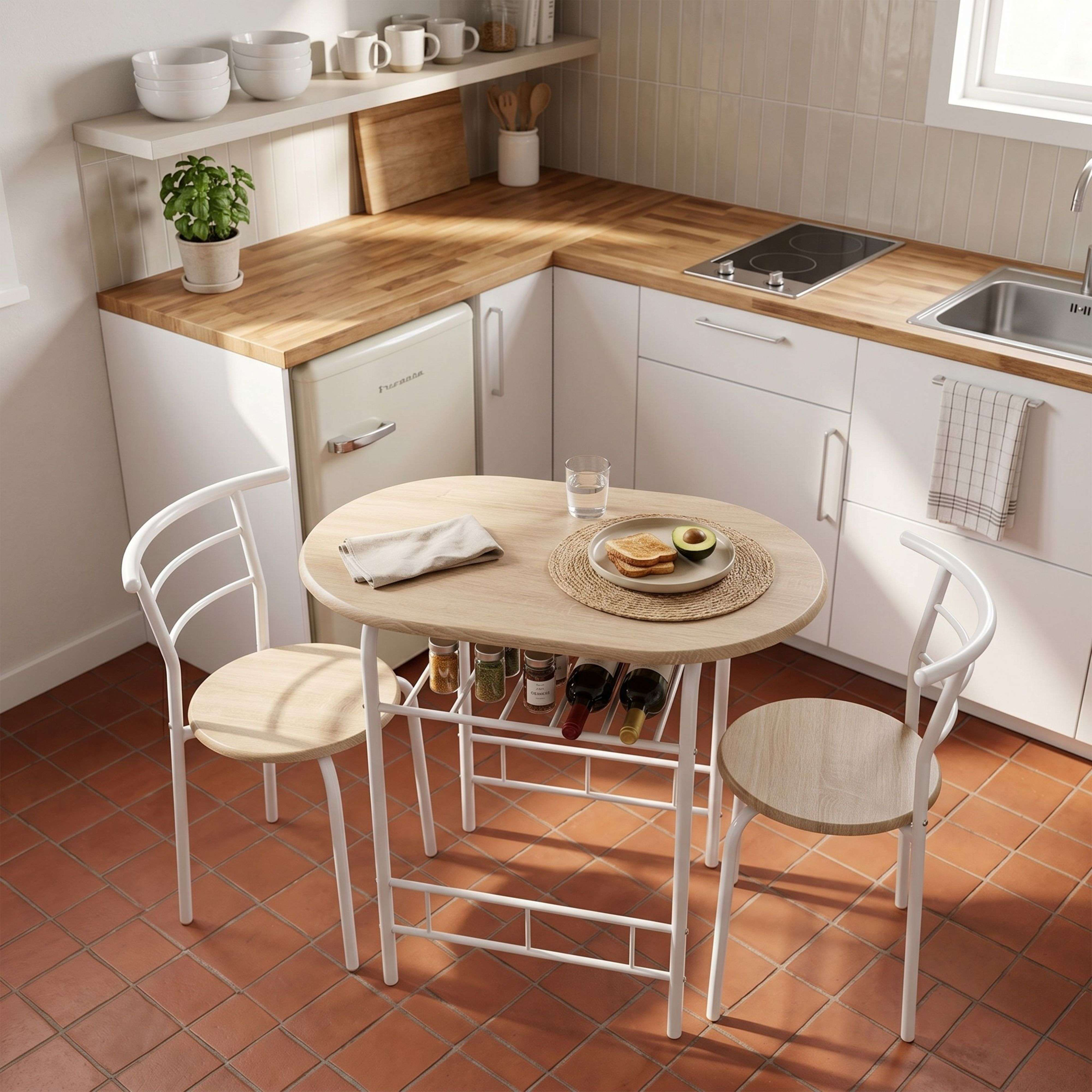 Una cocina pequeña con mesa de madera, dos sillas, nevera y fregadero.