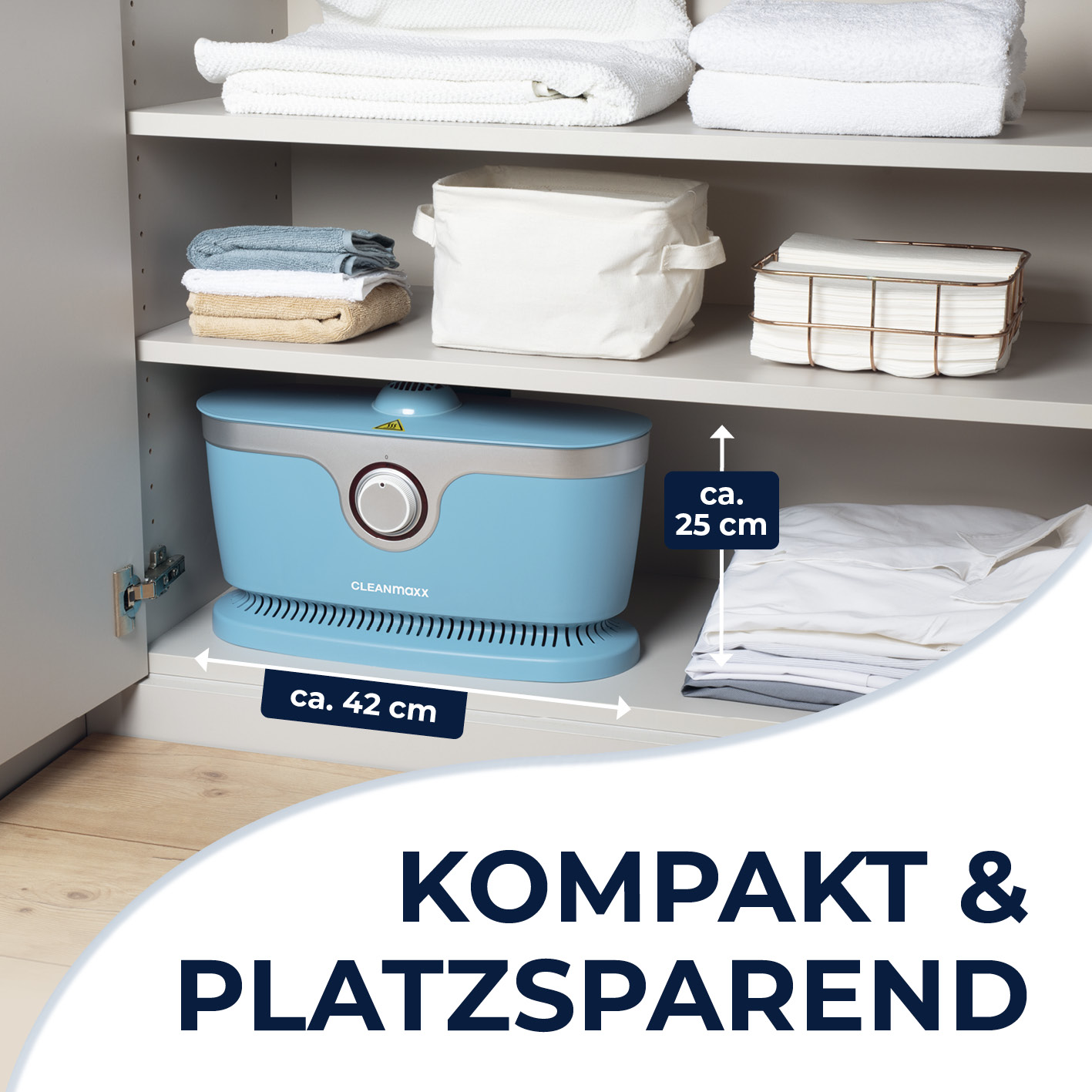 Ein blaues Gerät steht auf einem Regal neben gefalteten Handtüchern und Stoffkörben.