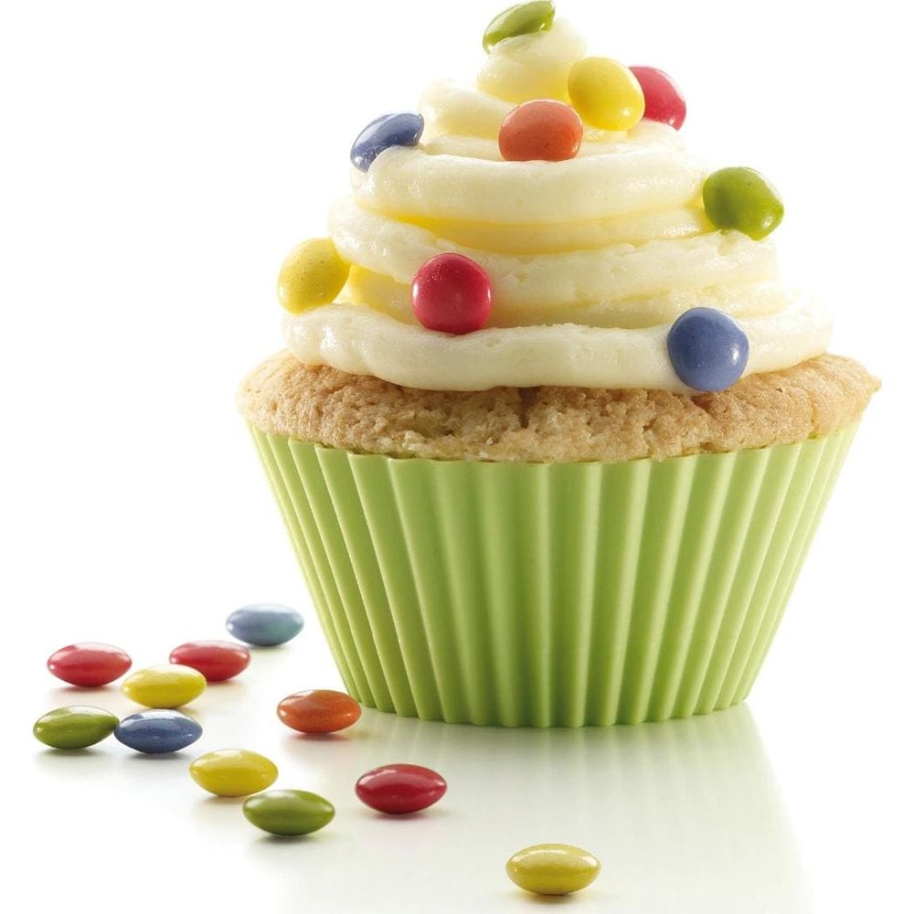 Un cupcake avec glaçage jaune et bonbons colorés, entouré de bonbons dispersés.