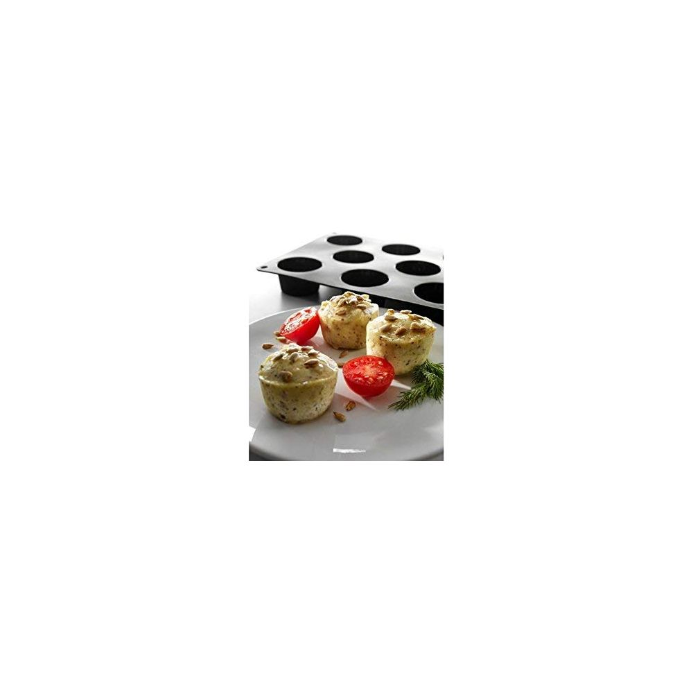 Trois muffins salés avec tomates et herbes sur une assiette à côté d'un moule.