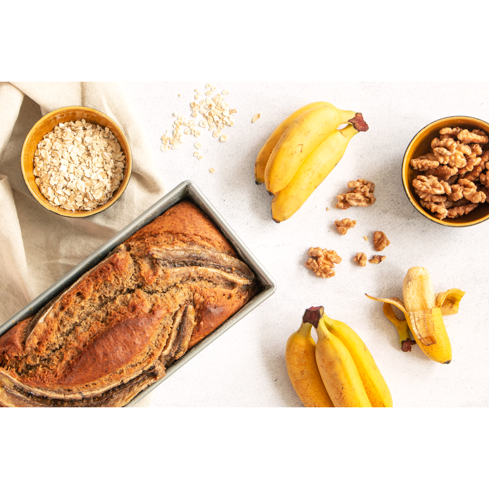 Bananenbrot in einer Kastenform, mit Bananen, Walnüssen und Hafer.