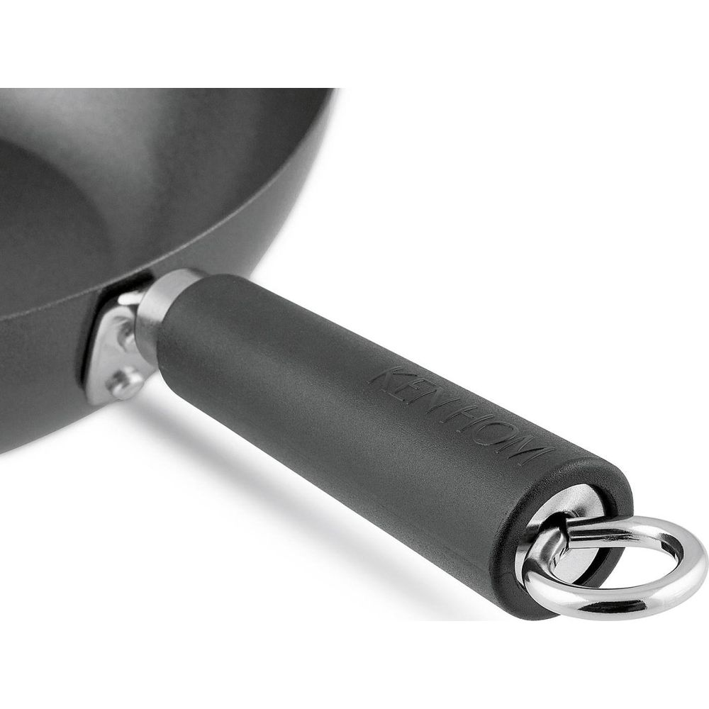 Gros plan d'un wok noir avec un manche noir et une boucle argentée.