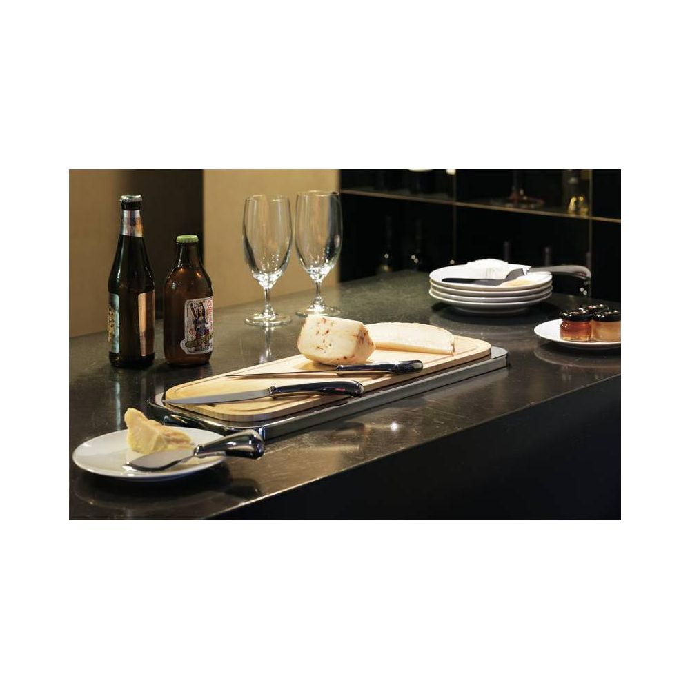 Due bottiglie di birra, bicchieri, formaggio su tagliere, vasetti di marmellata.