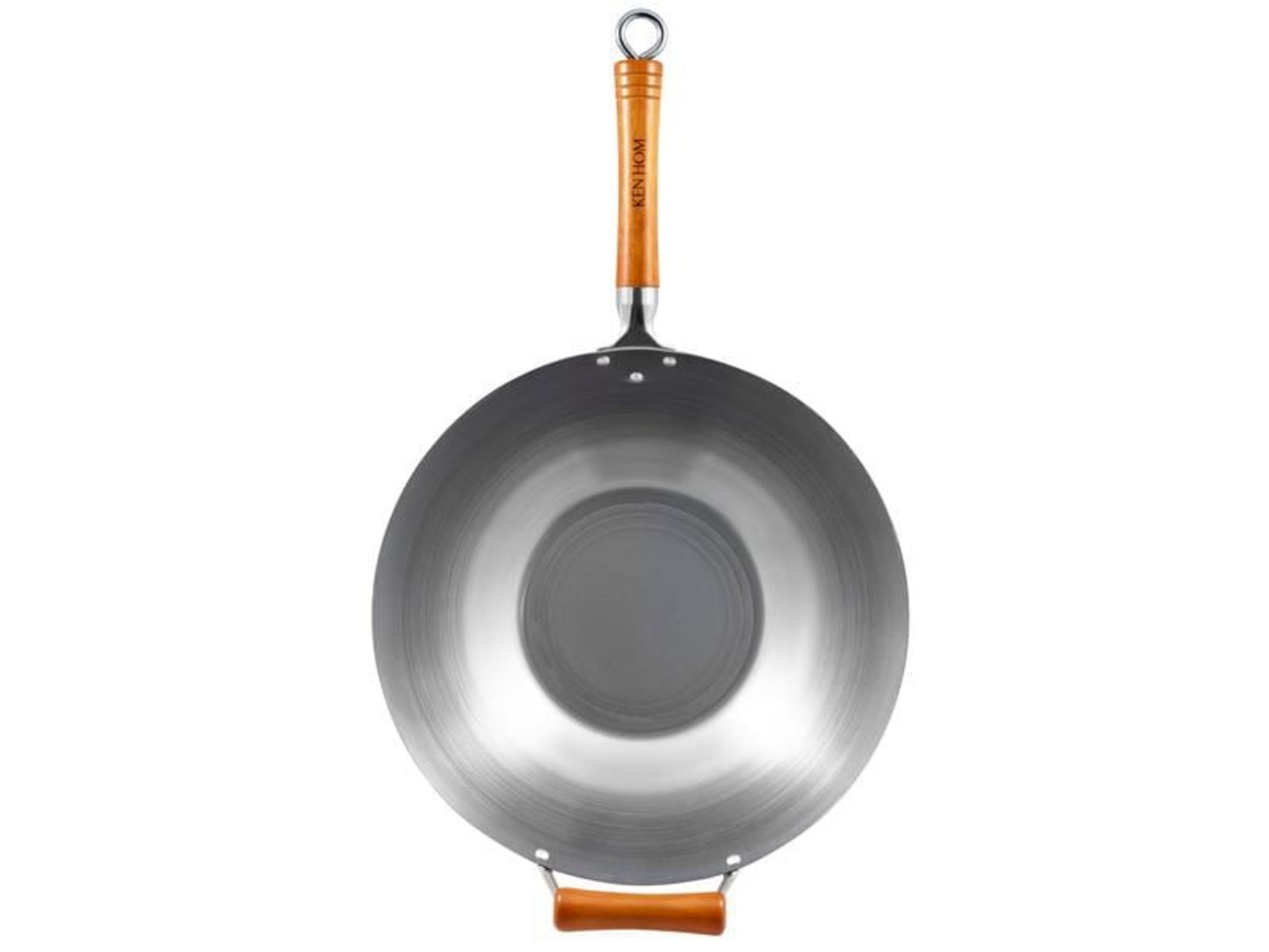 Un wok argenté avec un manche en bois et un manche en bois supplémentaire sur le côté.
