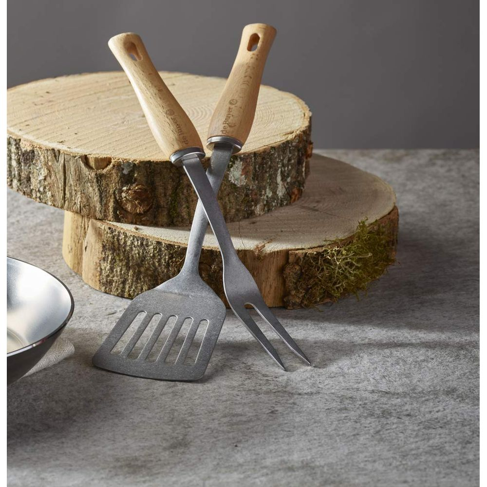 Utensili da barbecue in metallo con manici in legno su dischi.