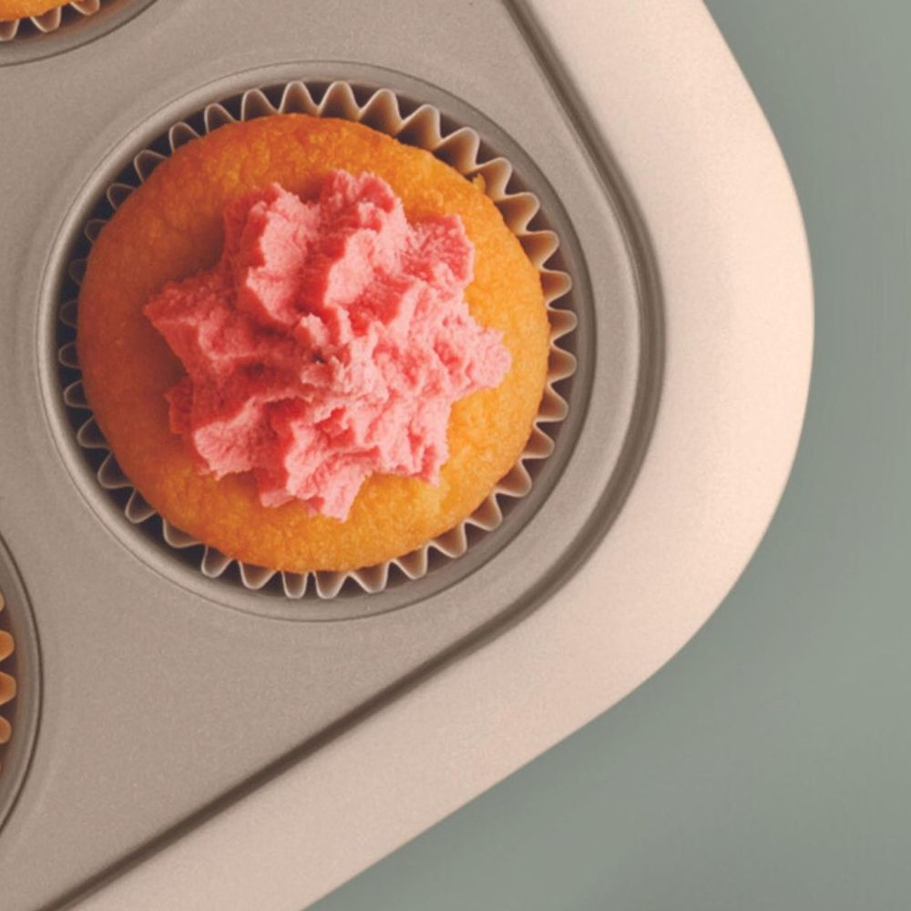 Ein einzelner Cupcake mit rosa Zuckerguss in einer metallischen Muffinform.