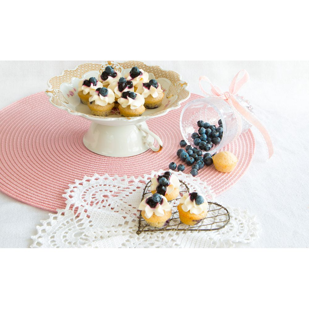 Mini cupcakes avec crème et myrtilles sur un plateau à gâteaux et un support en cœur.