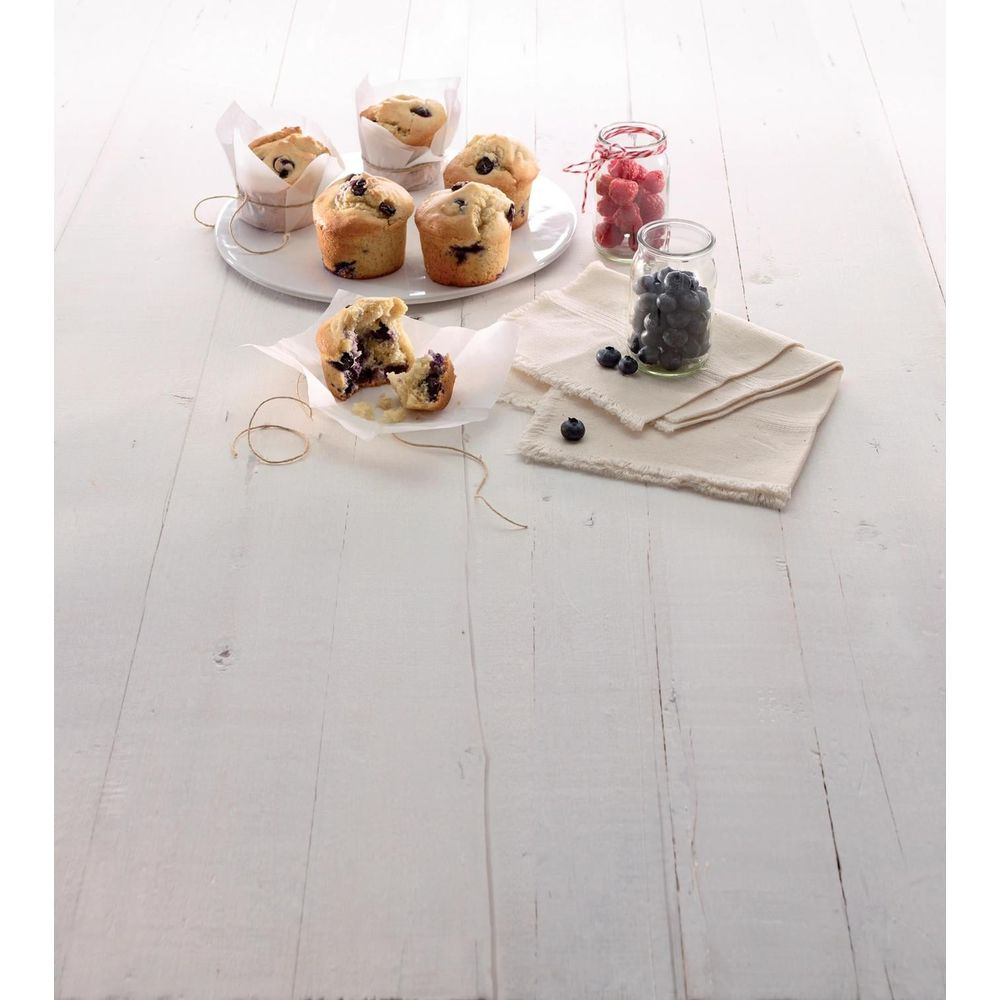 Muffins aux myrtilles et baies sur table en bois blanc.