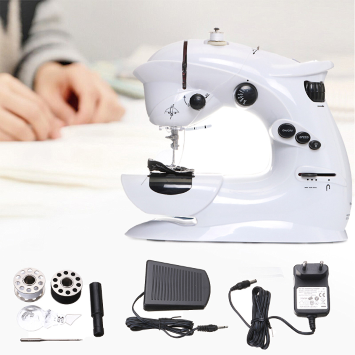 Máquina de coser blanca compacta con accesorios: pedal, adaptador de corriente, bobinas.