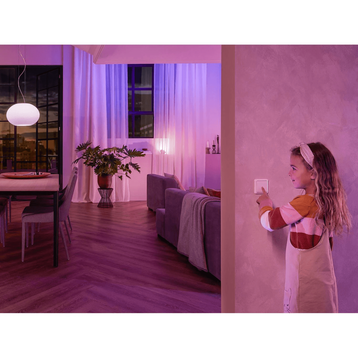 Mädchen drückt Lichtschalter in einem lila beleuchteten Wohnzimmer mit Möbeln.