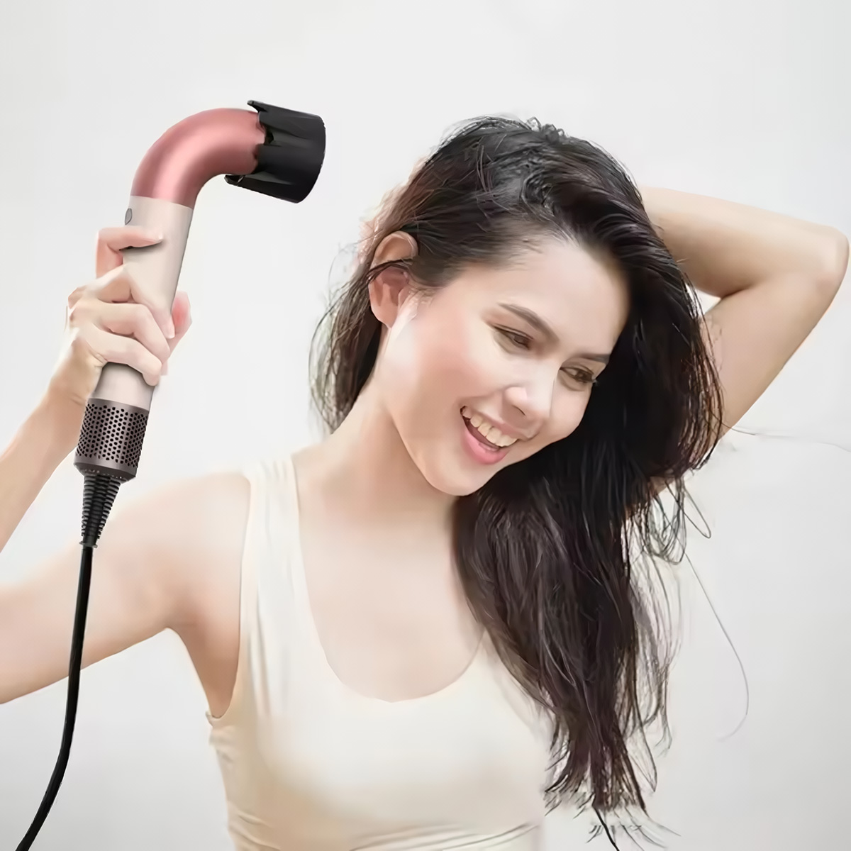 Una mujer de pelo castaño se seca el pelo mojado con un secador rosa y blanco.