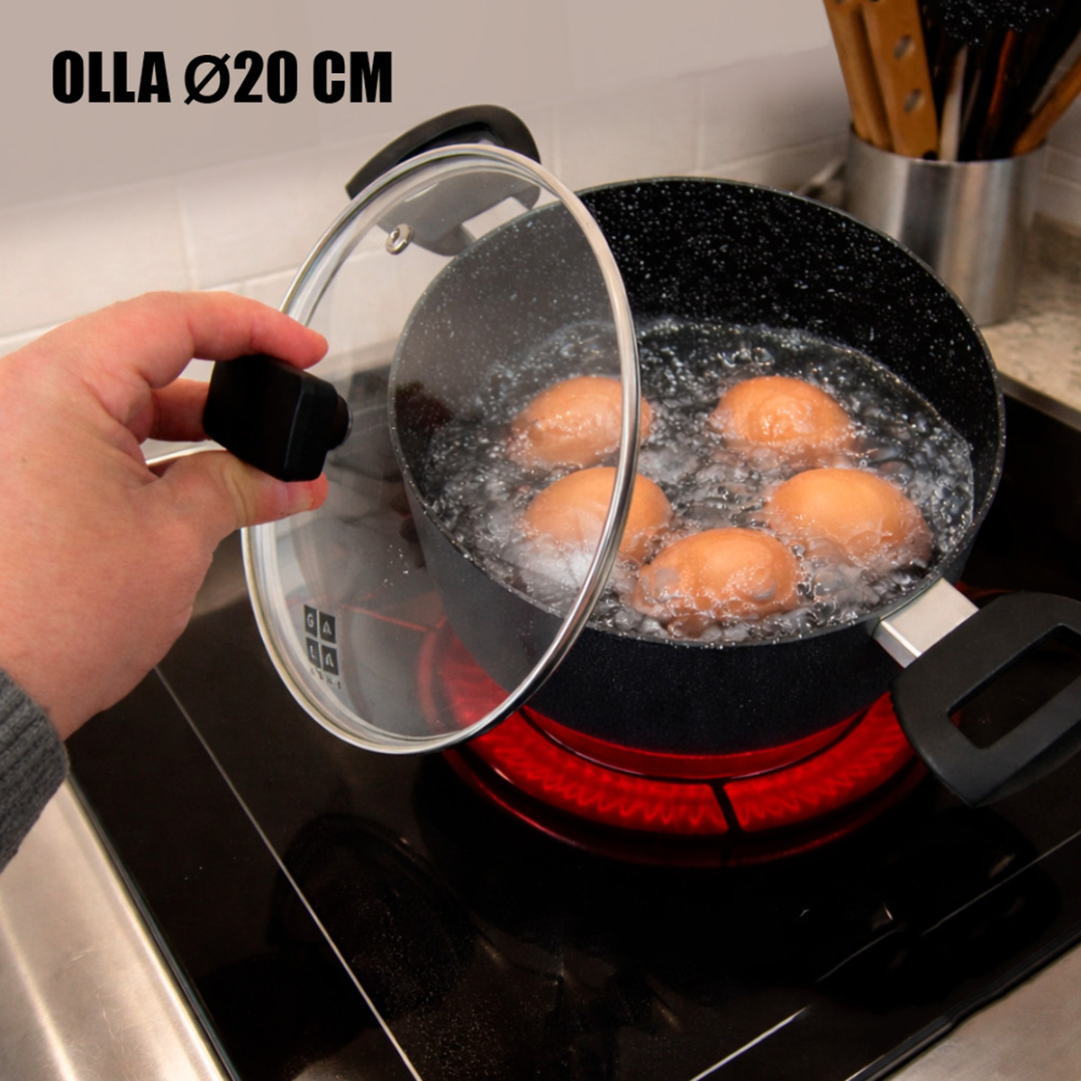 Cinco huevos hirviendo en una olla en una estufa, una mano levanta la tapa.