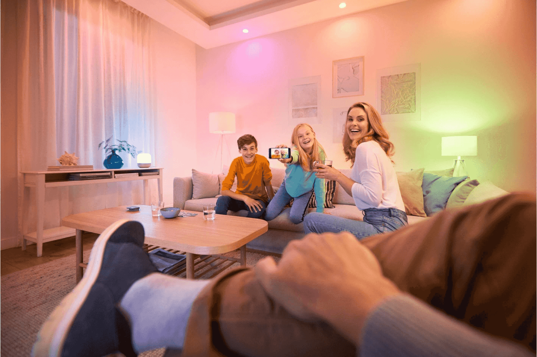 La familia se toma una selfie en una sala con luces de colores.