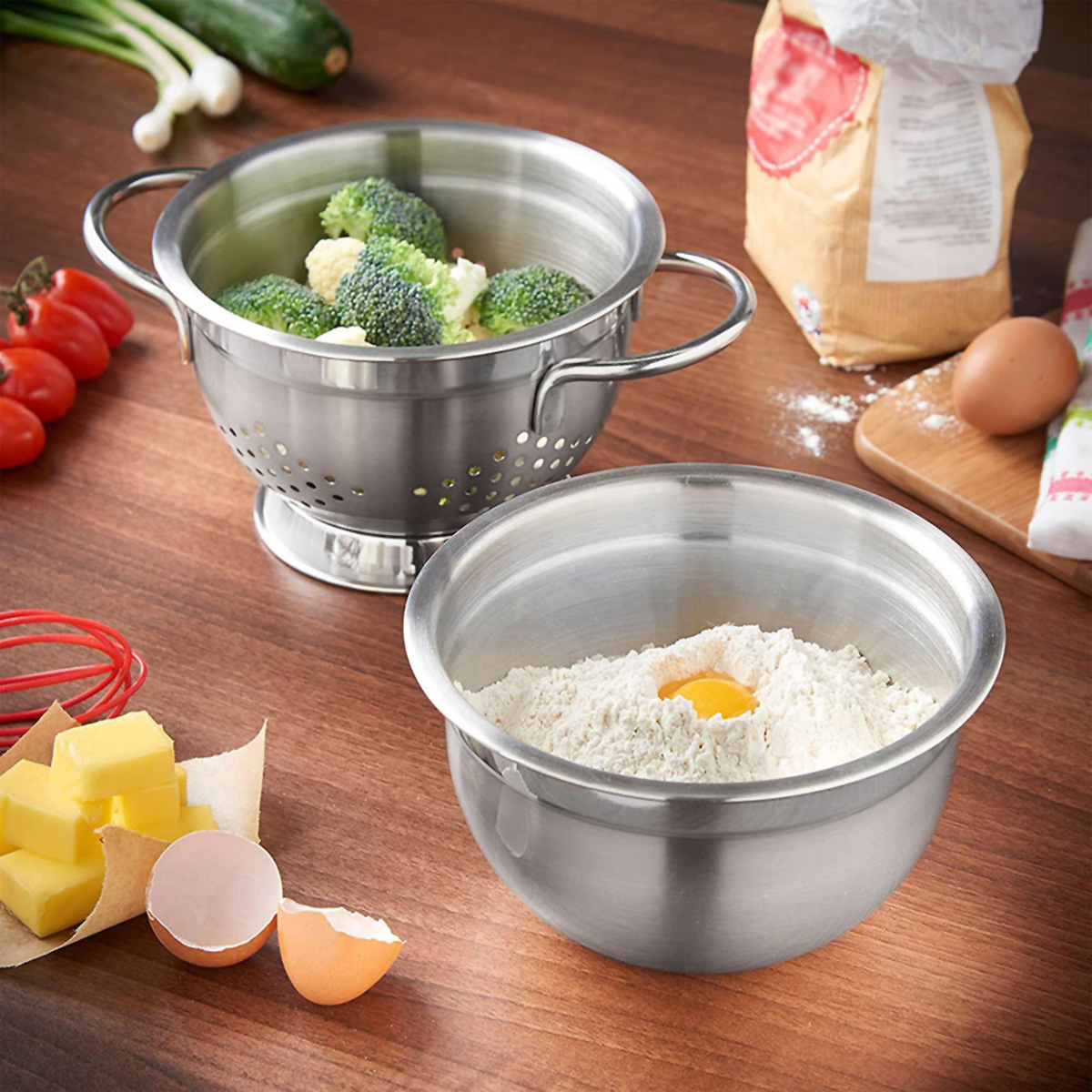 Bol de acero inoxidable con harina y huevo, al lado de un bol con brócoli y verduras.