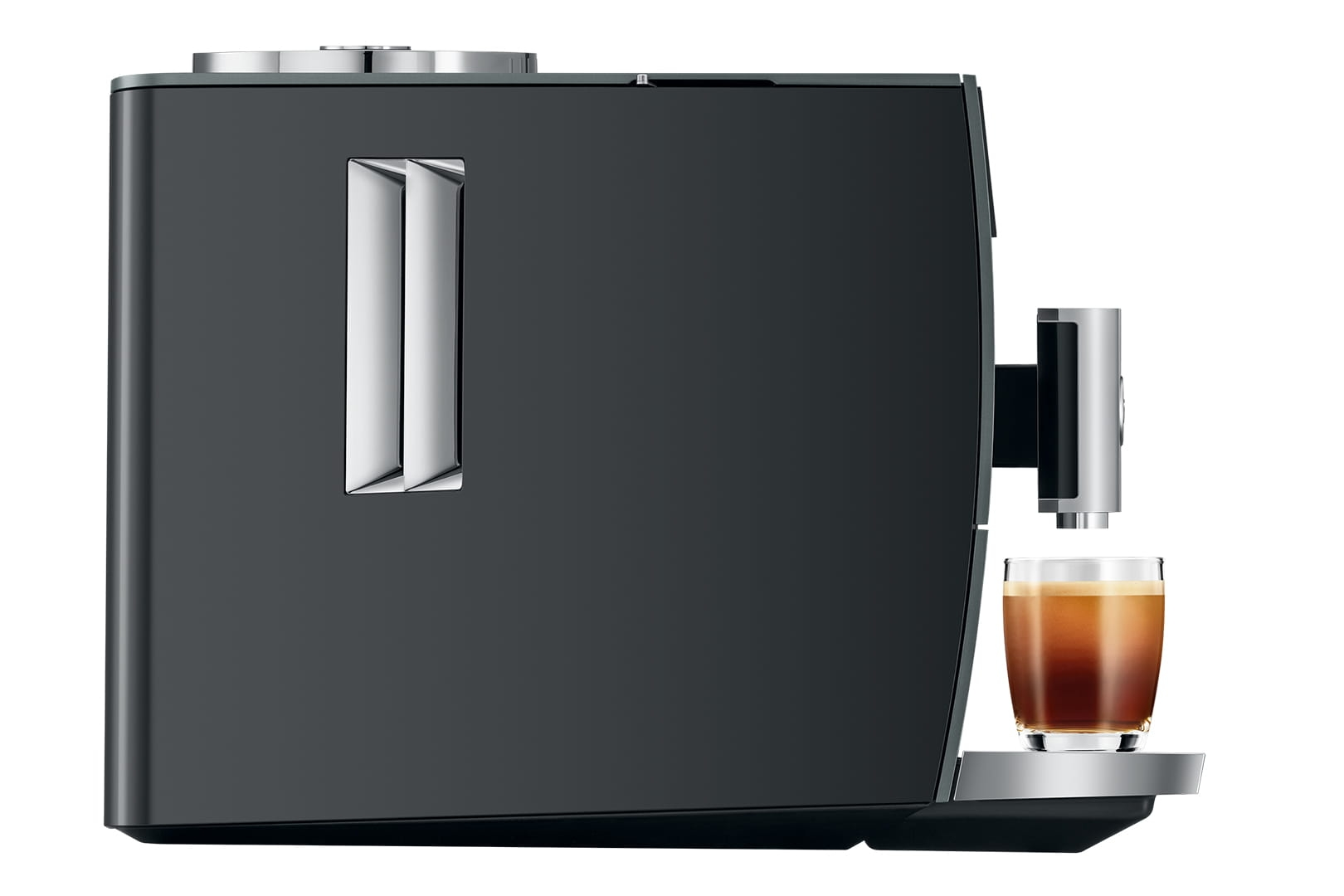 Una macchina da caffè scura con un bicchiere di espresso accanto.