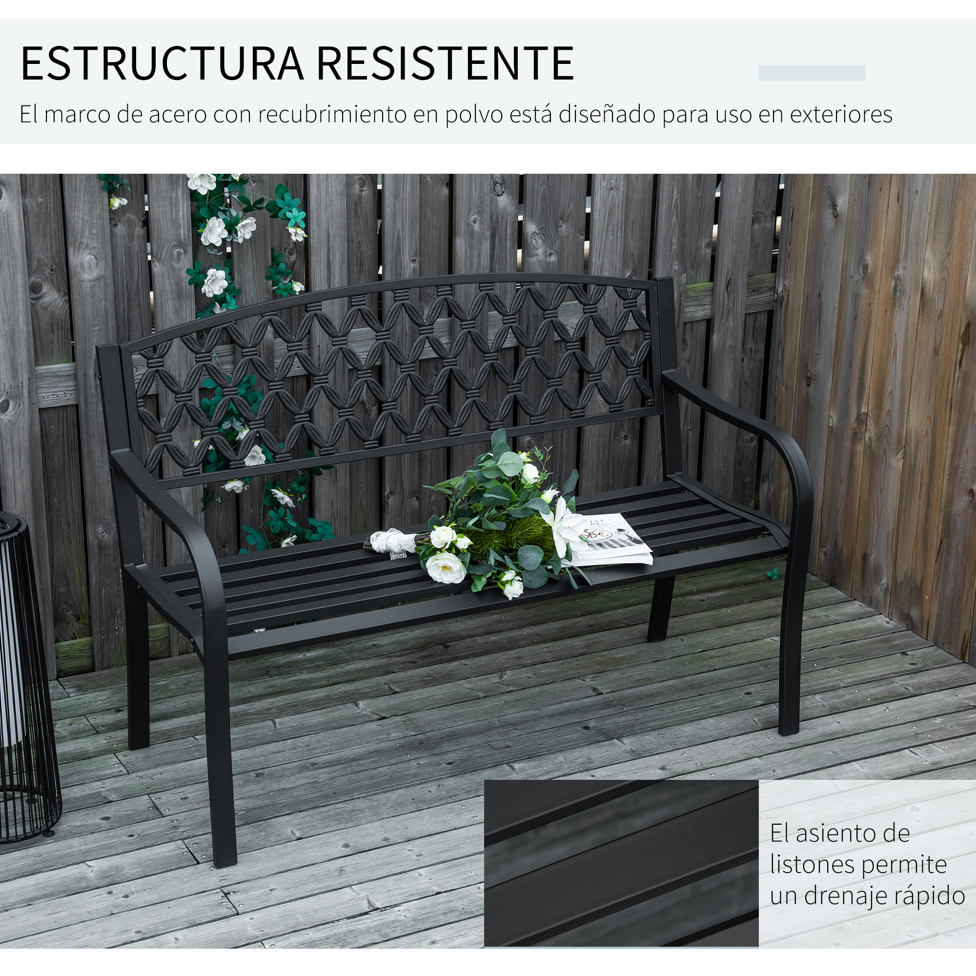 Un banco de metal negro con flores y un libro en una terraza de madera.
