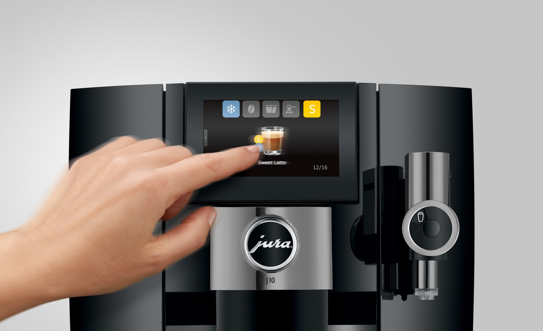 Una mano tocca lo schermo di una macchina da caffè che mostra 