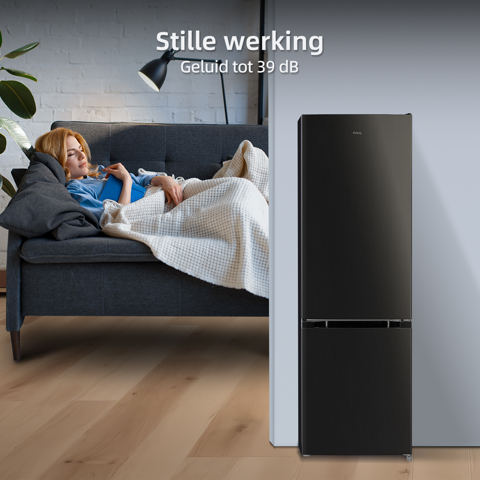 A woman sleeps on a couch next to a black refrigerator.