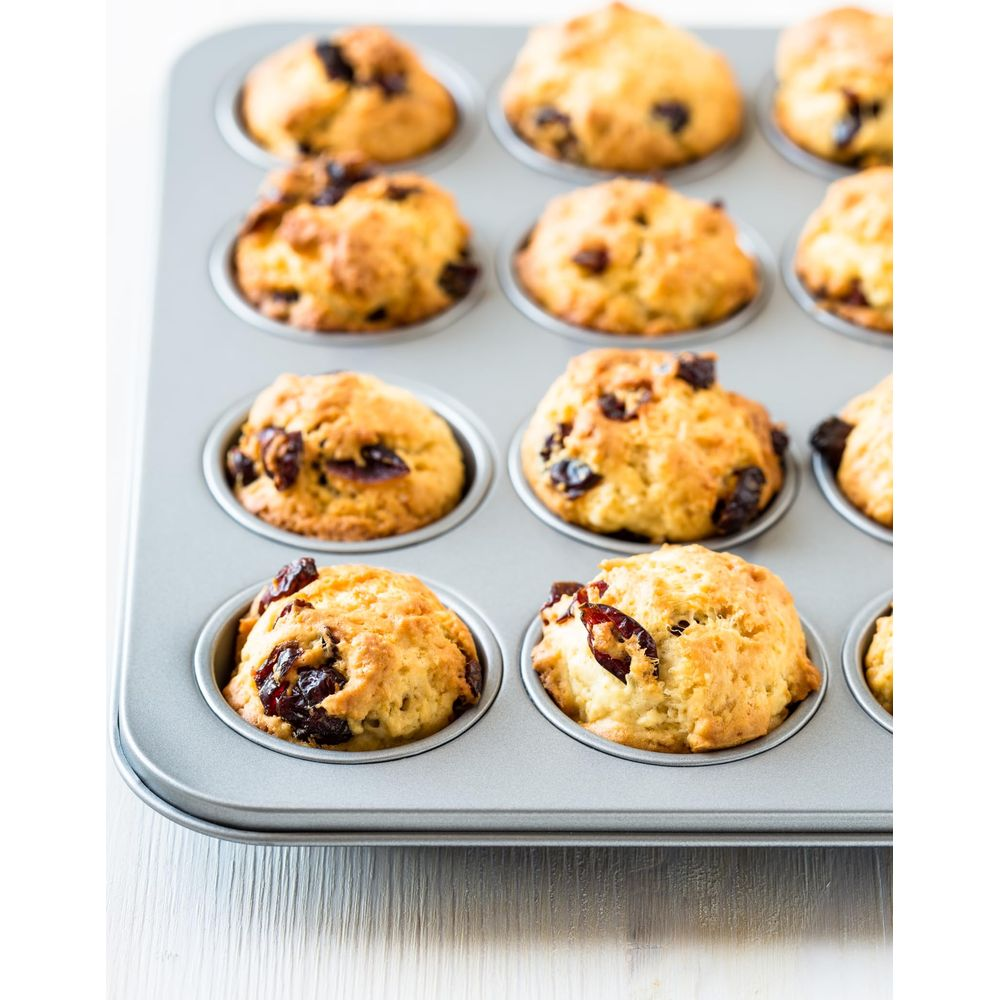 Forma do muffinek z 12 świeżo upieczonymi muffinkami z rodzynkami.