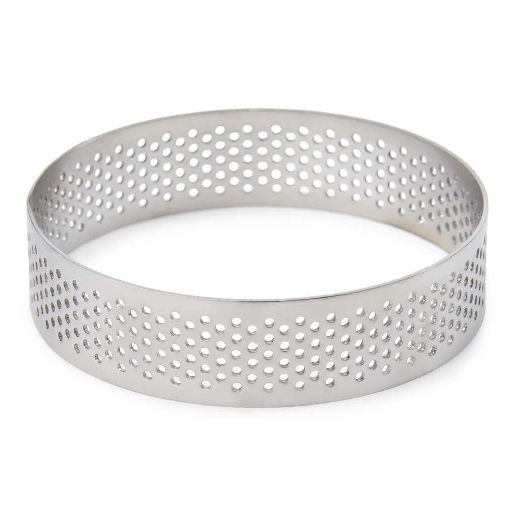 Perforowany metalowy pierścień do pieczenia na białym tle.