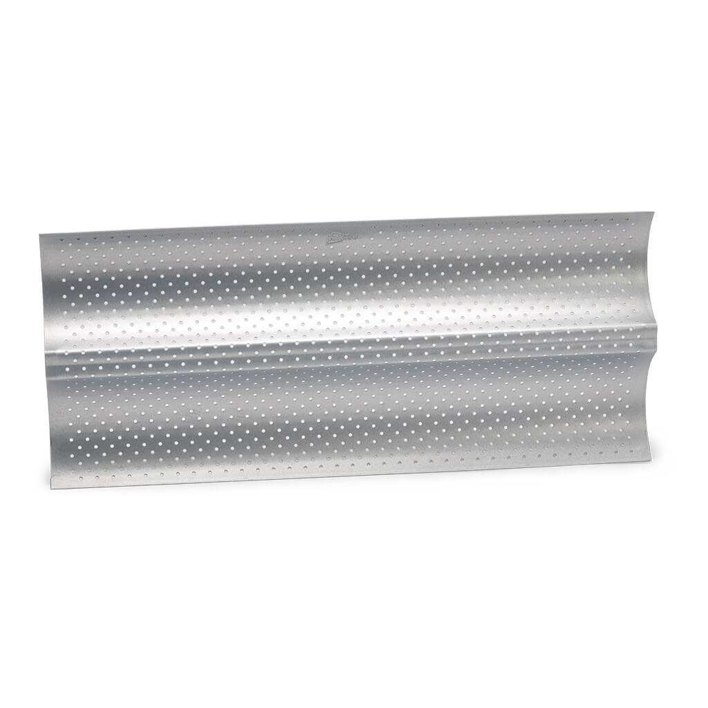 Perforowana metalowa forma do pieczenia z falistym wzorem. Białe tło.