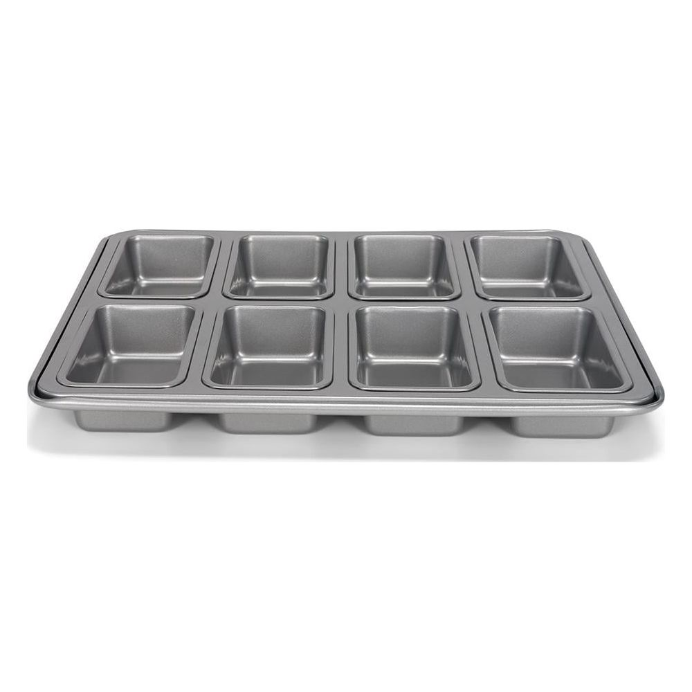 Szara metalowa forma do pieczenia z ośmioma kwadratowymi wgłębieniami na mini bochenki lub brownie.